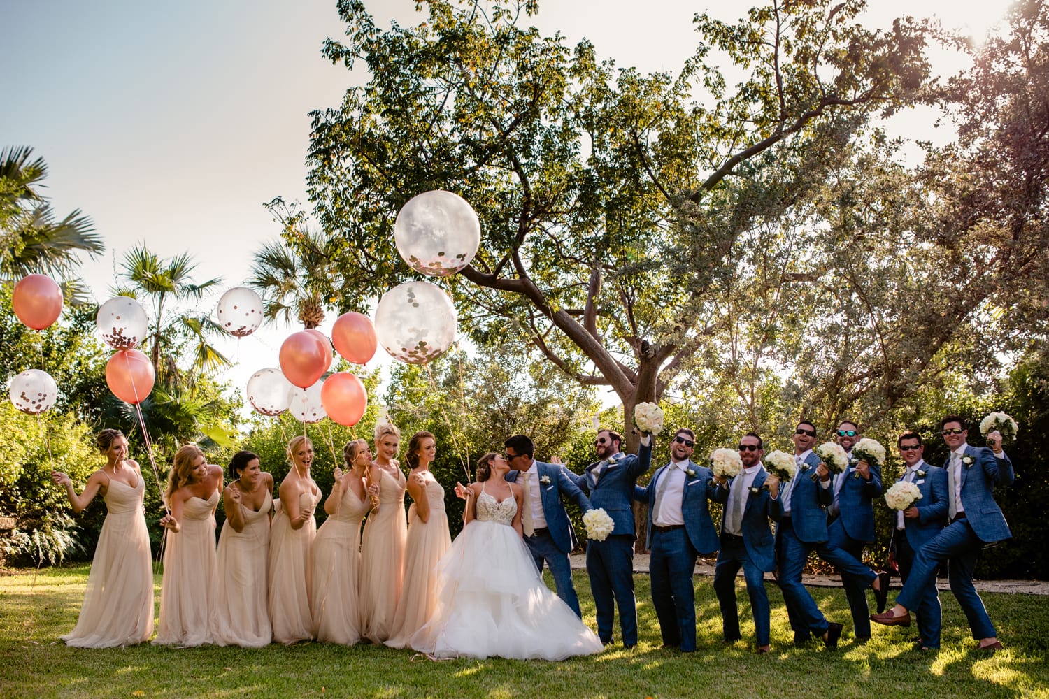 A group of bridesmaids and groomsmen holding balloons at a Casa Marina wedding.