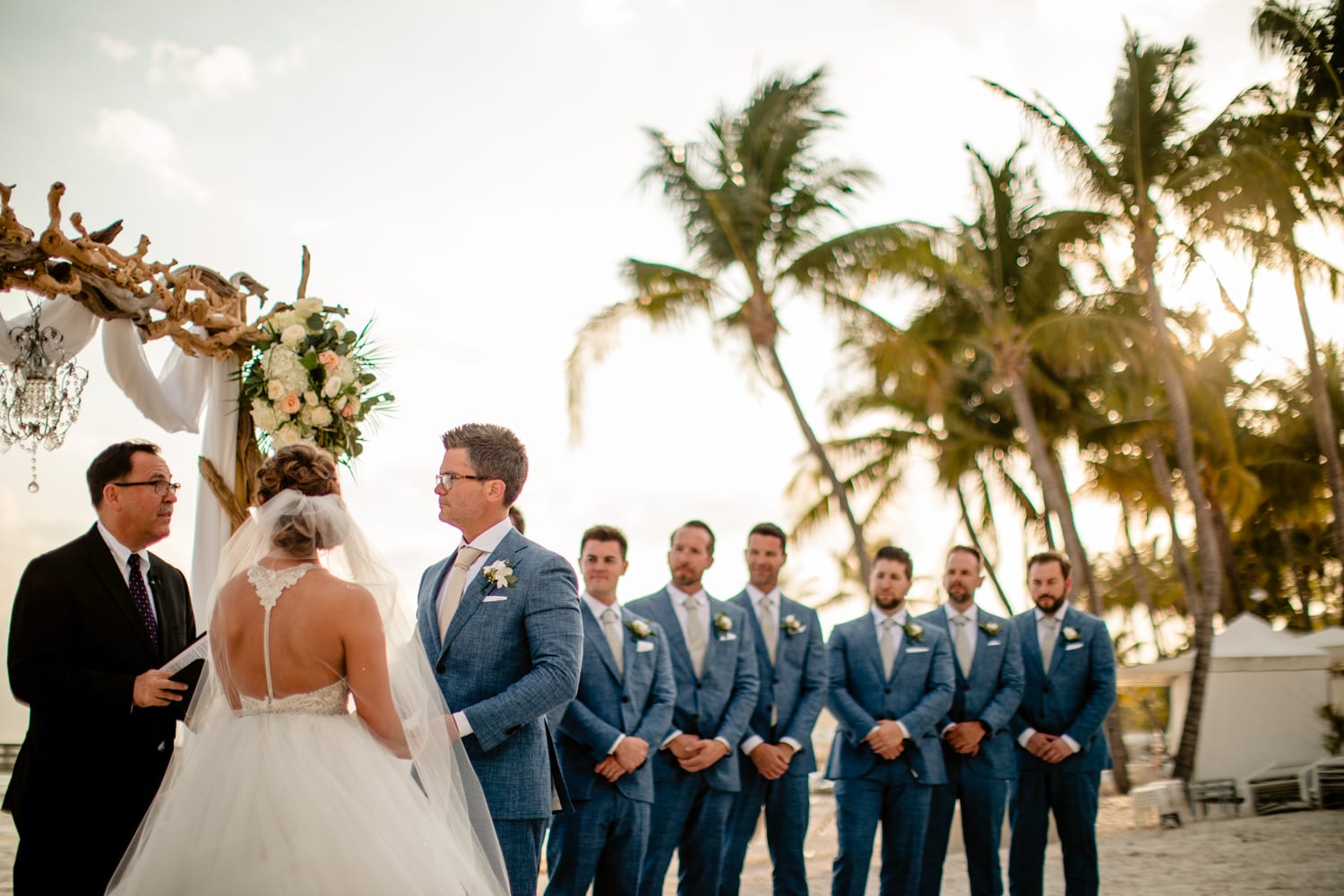 A Casa Marina wedding ceremony on the beach with bridesmaids and groomsmen.