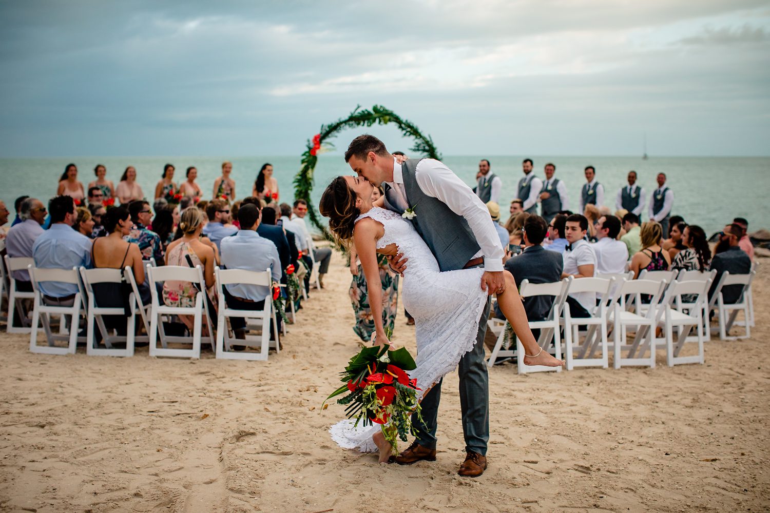 groom dipping bride at end of aisle sunset key wedding