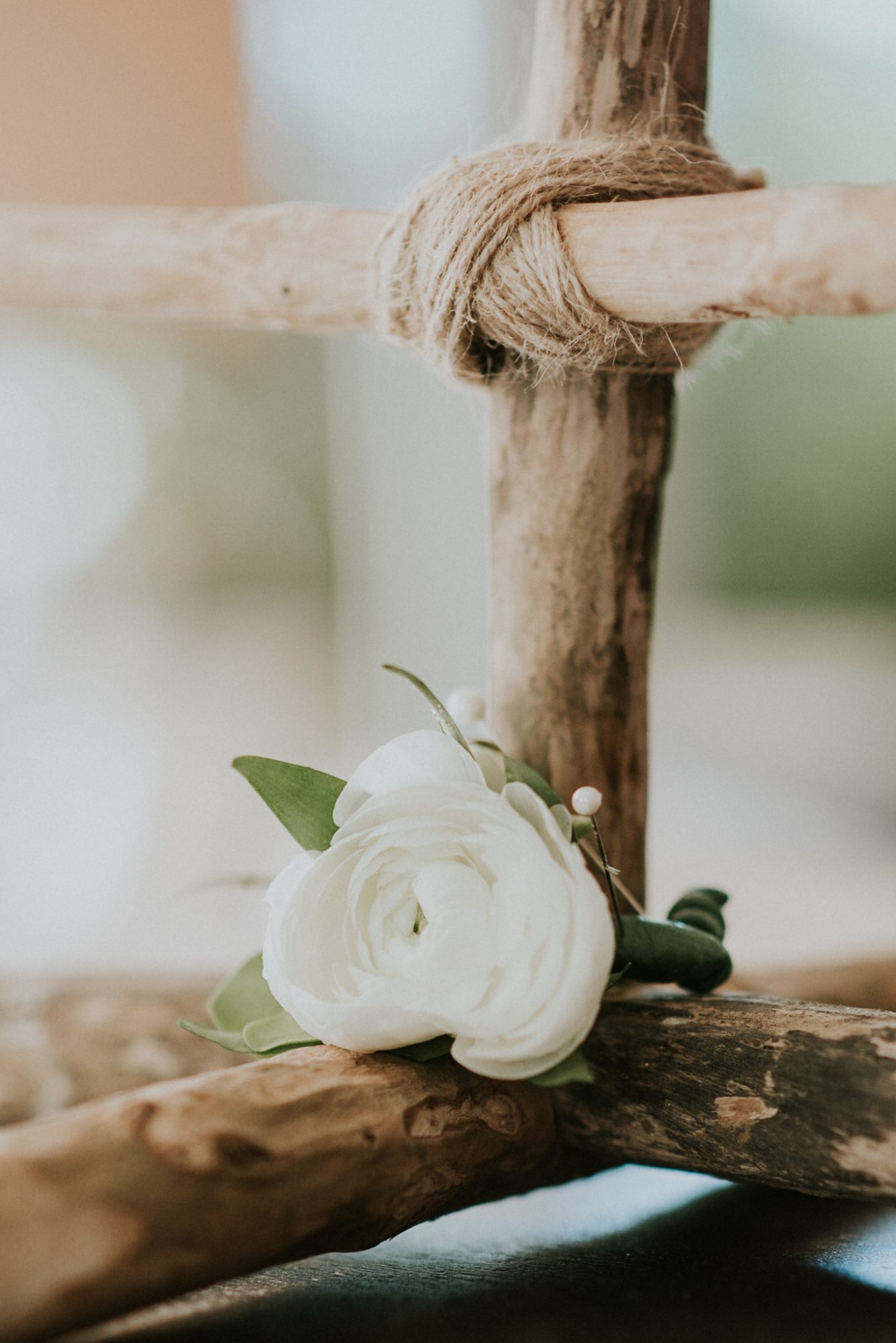 A white flower adorns a wooden stick.