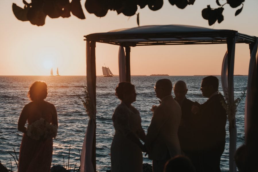 A sunset beach wedding ceremony in the Caribbean captured by a Key West Wedding Photographer.