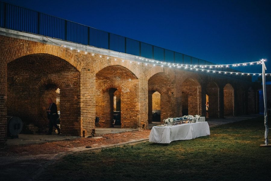 A night wedding reception in Key West in front of a brick building at Fort Zachary Taylor.