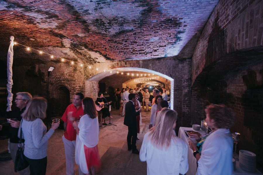 Key West Wedding Photographer capturing a group of people in a dark tunnel at Fort Zachary Taylor Wedding.