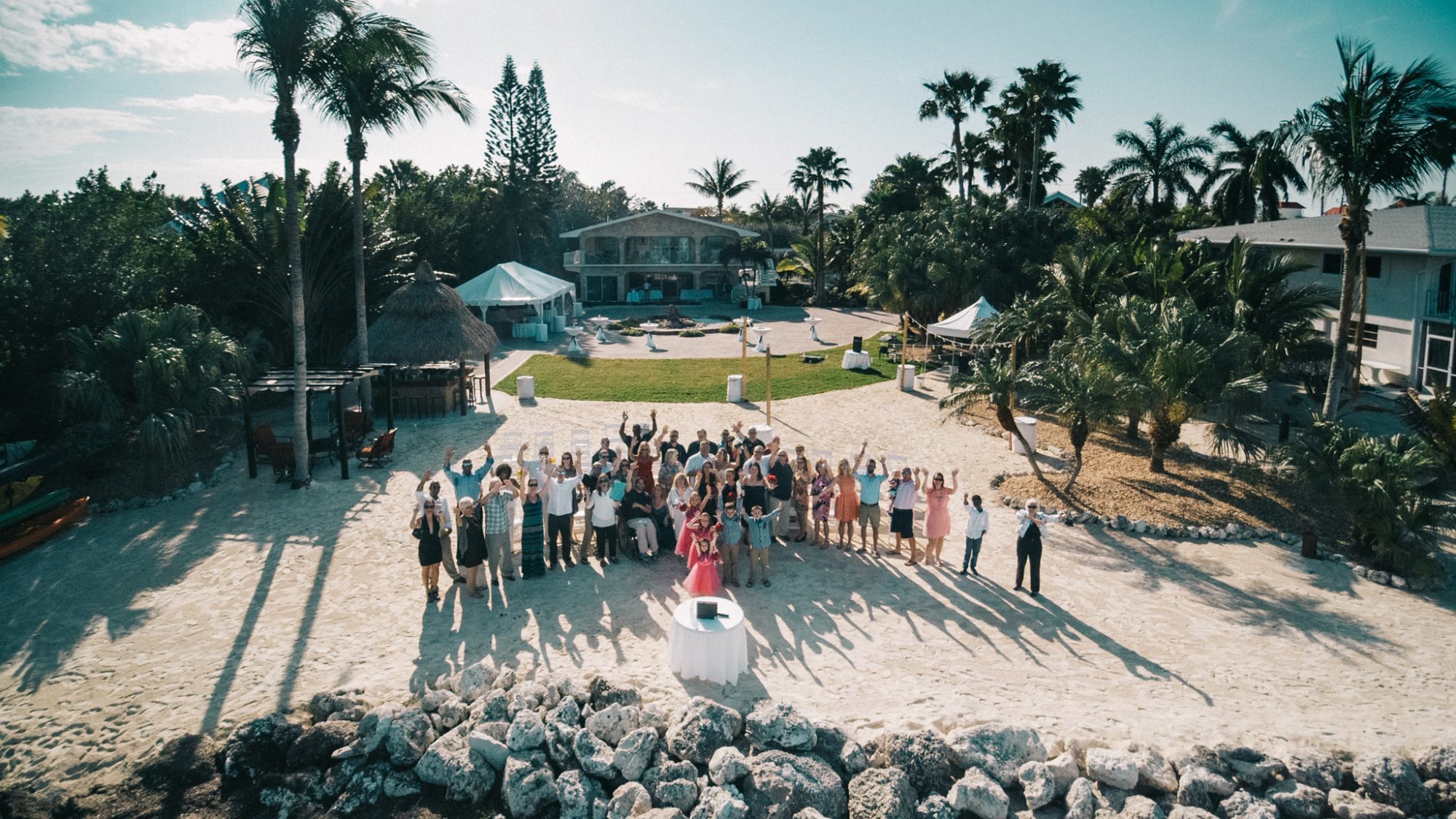 A group of people posing for a photo during a destination wedding in the Florida Keys on the beach.