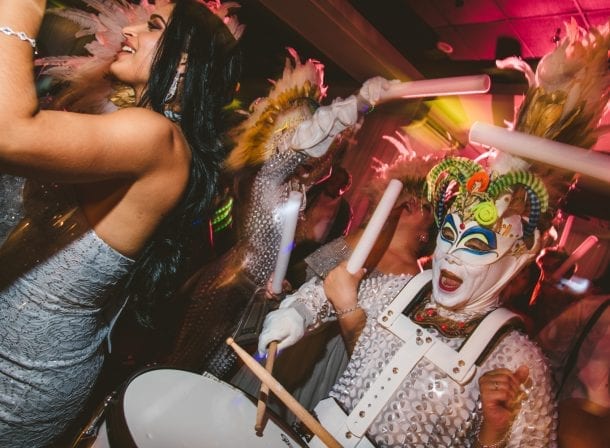A group of people dressed up in masks and costumes at a coral gables wedding party.