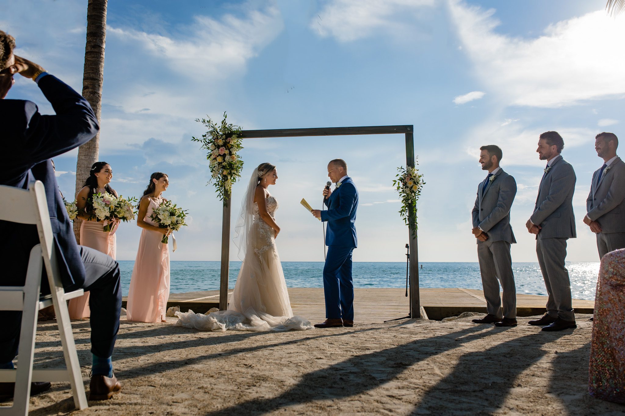 A wedding ceremony on the beach with a bride and groom.