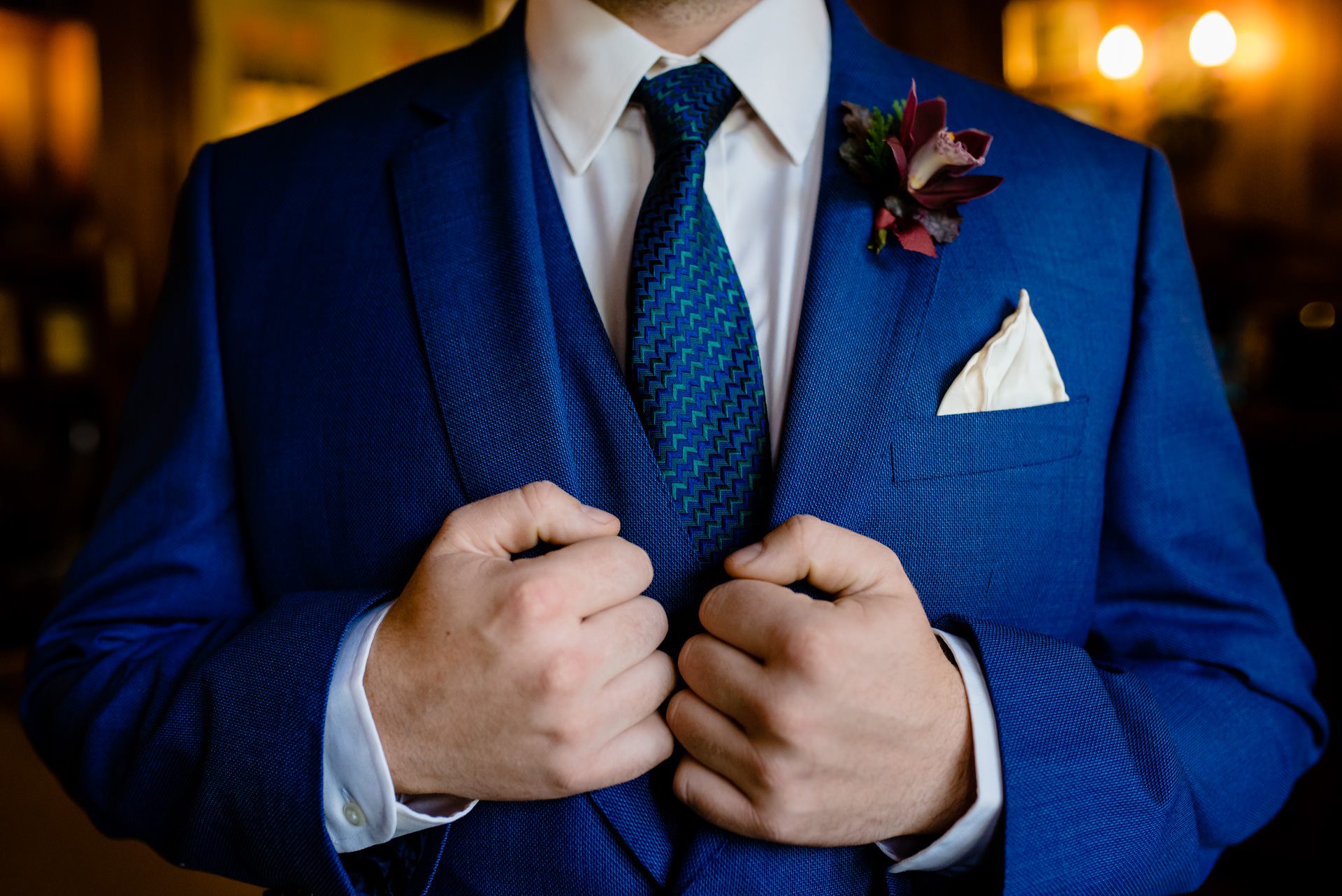 Groom holding the lapels of his suit before getting married in north carolina