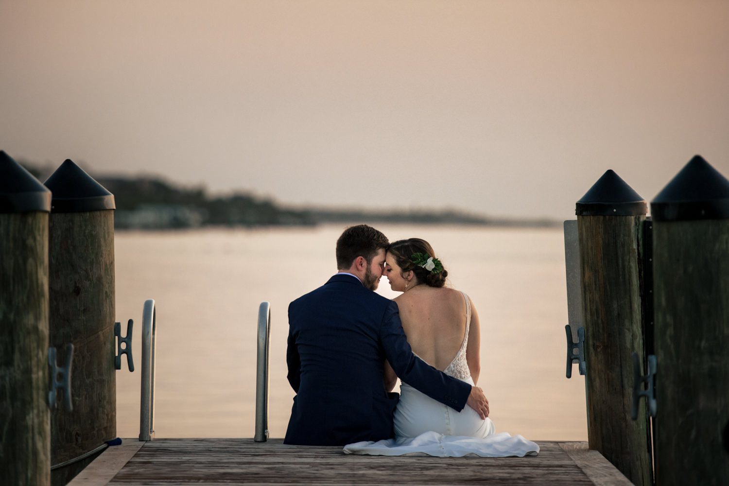 Newlywed couple sitting on a pier in playa largo