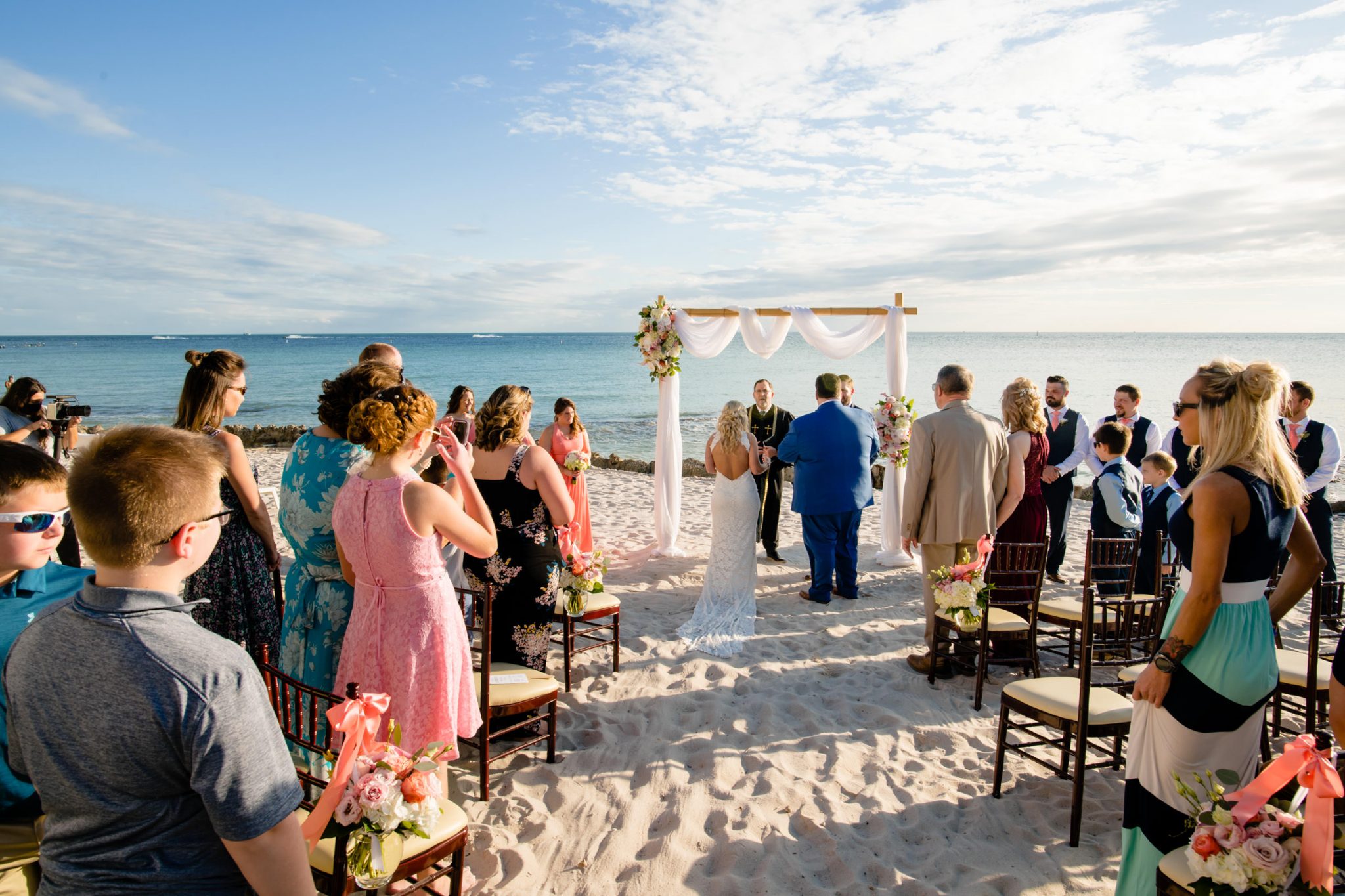 father walking daughter down aisle of beach wedding