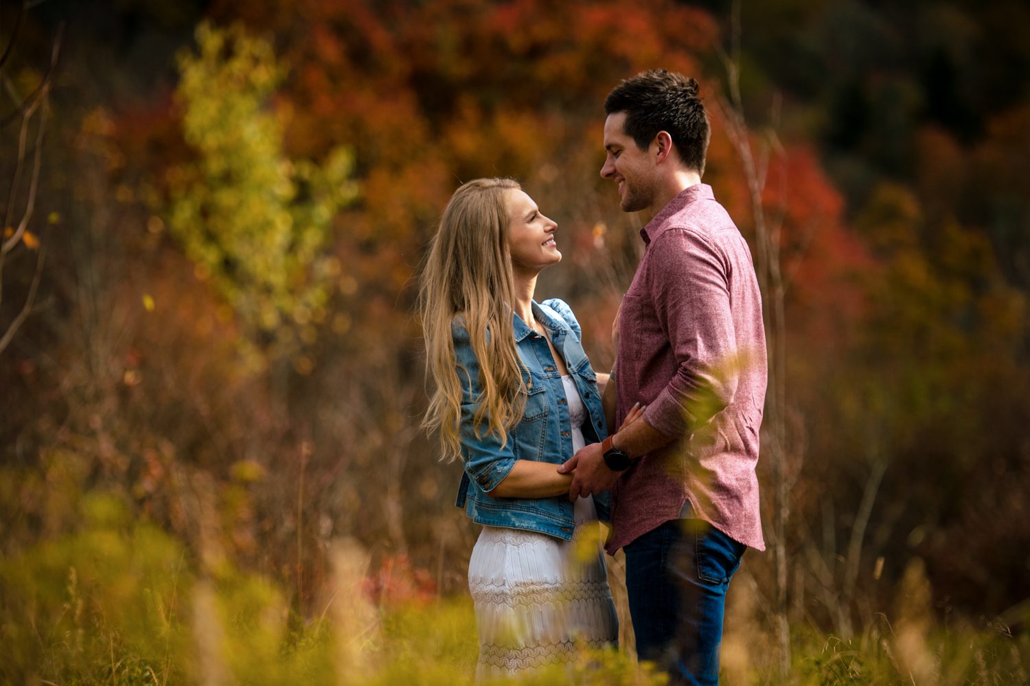 couple embracing in field asheville engagement photos