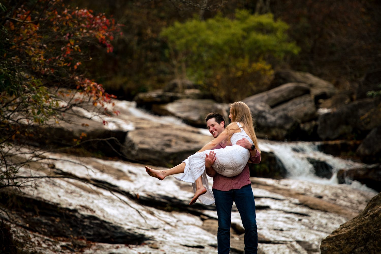 couple playing in waterfall asheville engagement photos