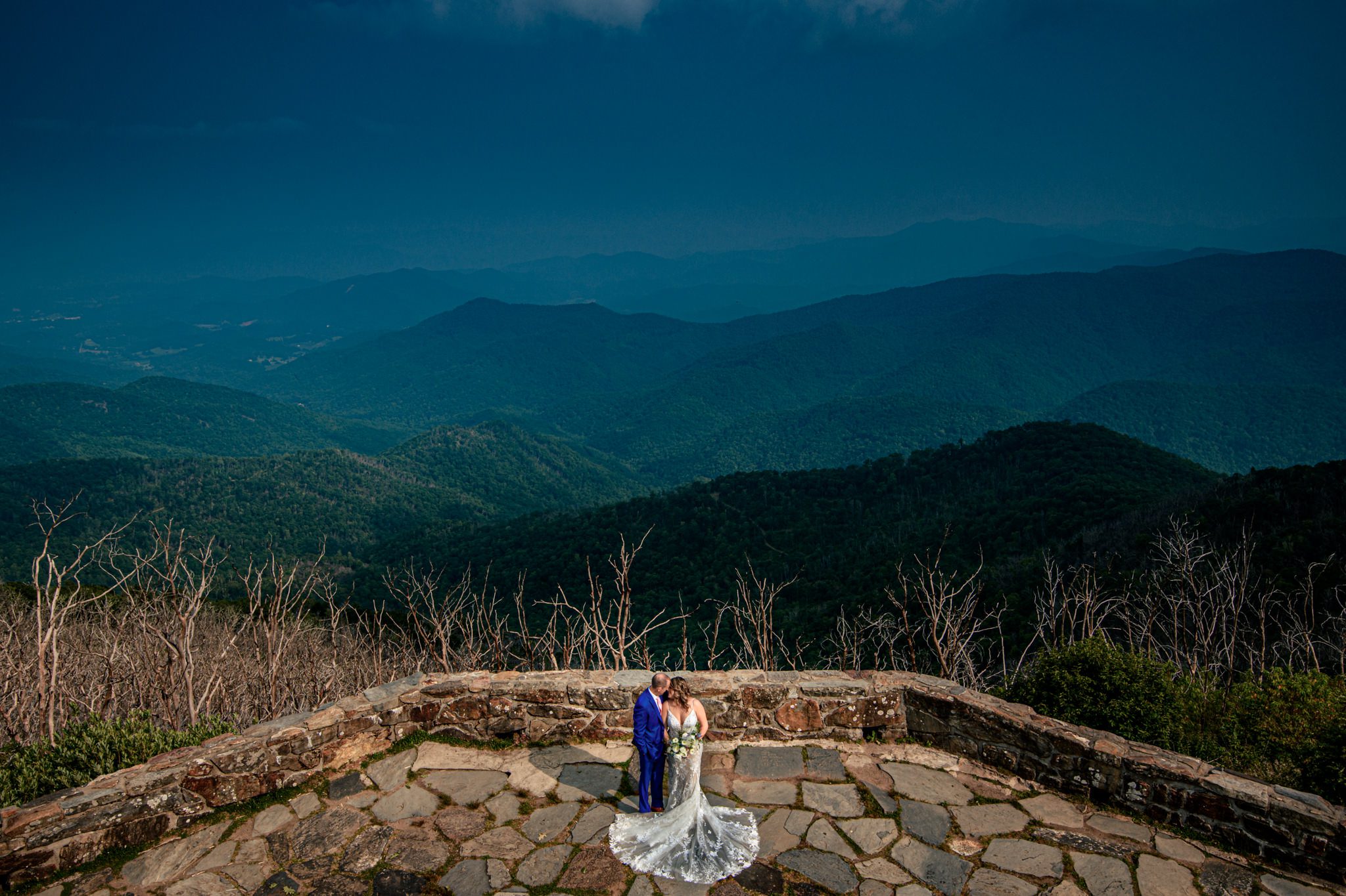 bride and groom holding each other at wayah bald lookout tower