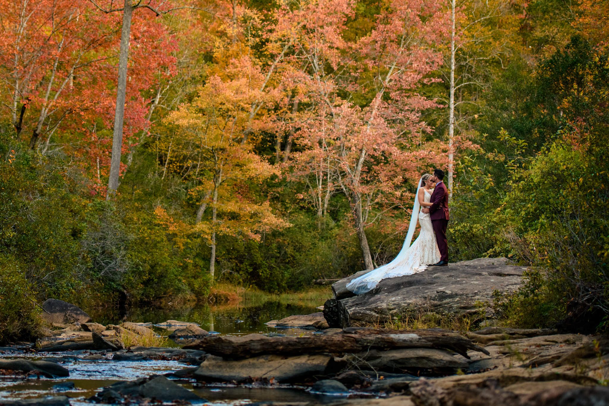 bride and groom portraits with fall leaves behind them