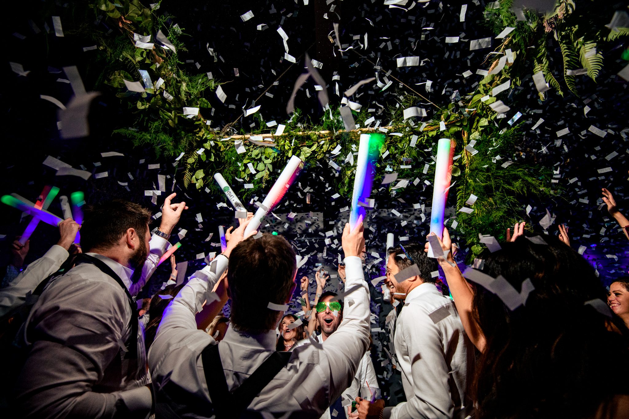 confetti cannons dropping confetti all over the dancing wedding party