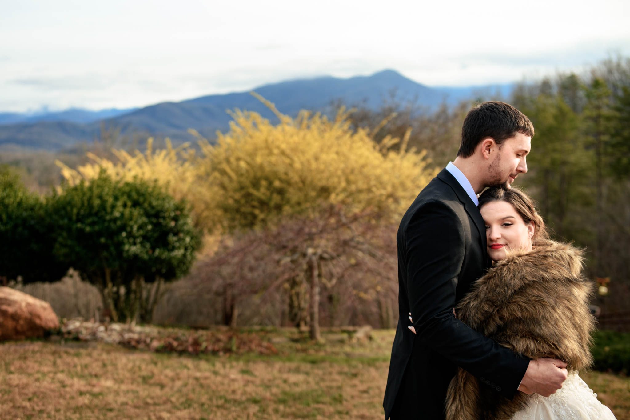 Bride and groom embracing each other in front of Mount Leconte