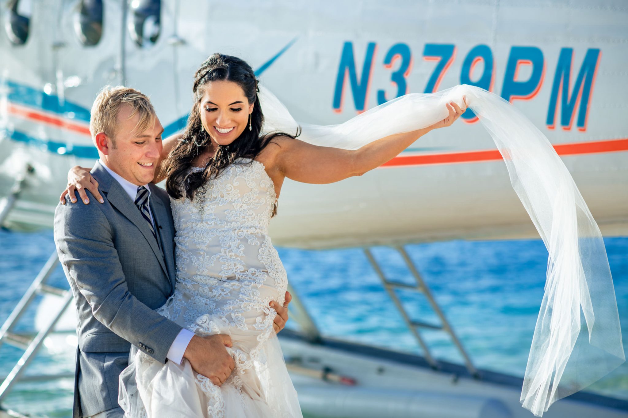 Groom carrying bride across the water from a seaplane in the dry Tortugas national Park