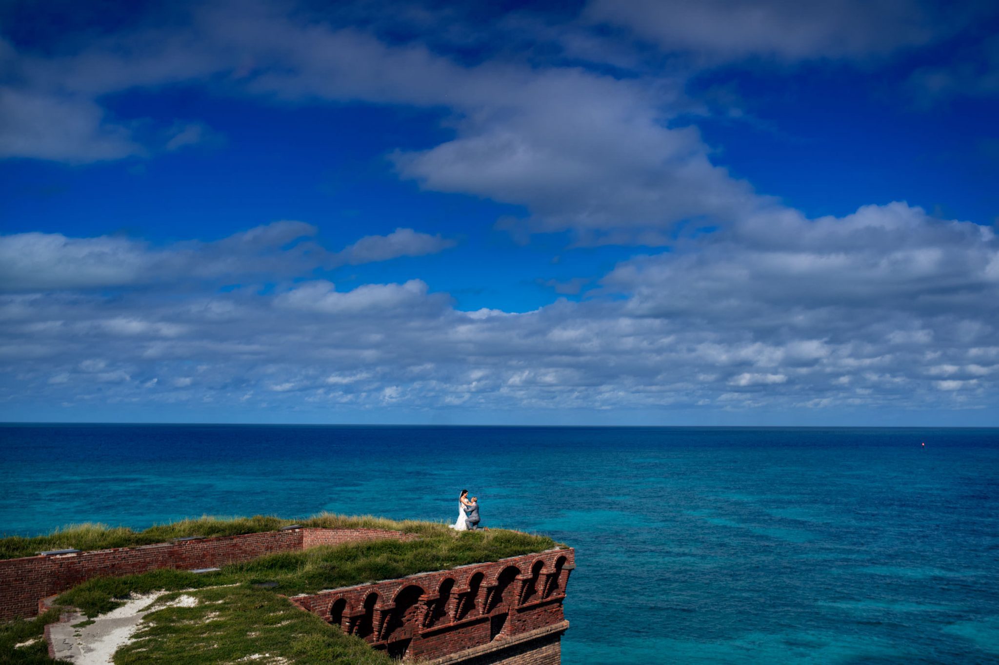 environmental landscape portrait of bride and groom on top of fort jefferson in the dry tortugas national park