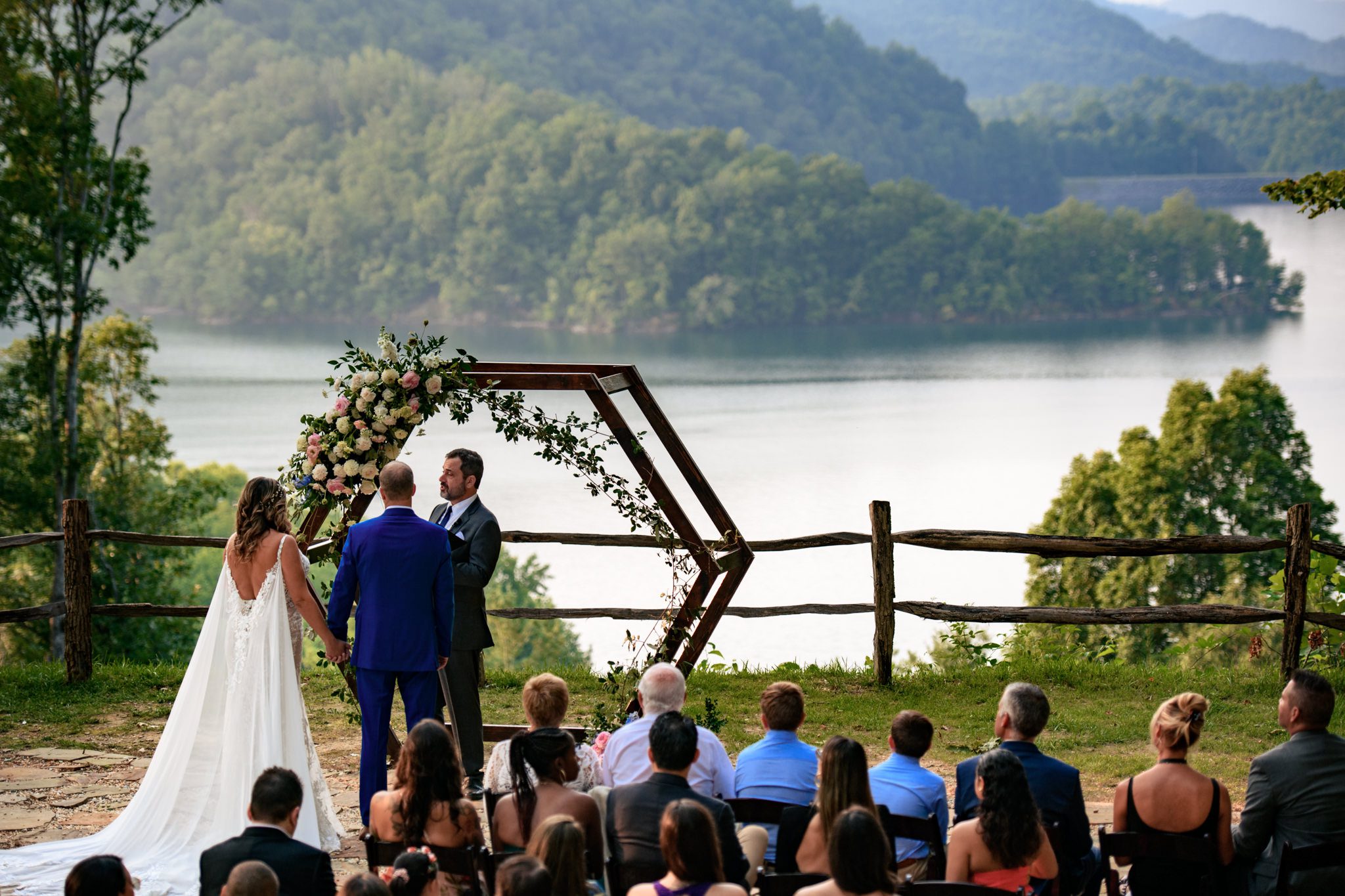 Bride and groom standing underneath arbor at Nantahala wedding shot while being a second photographer