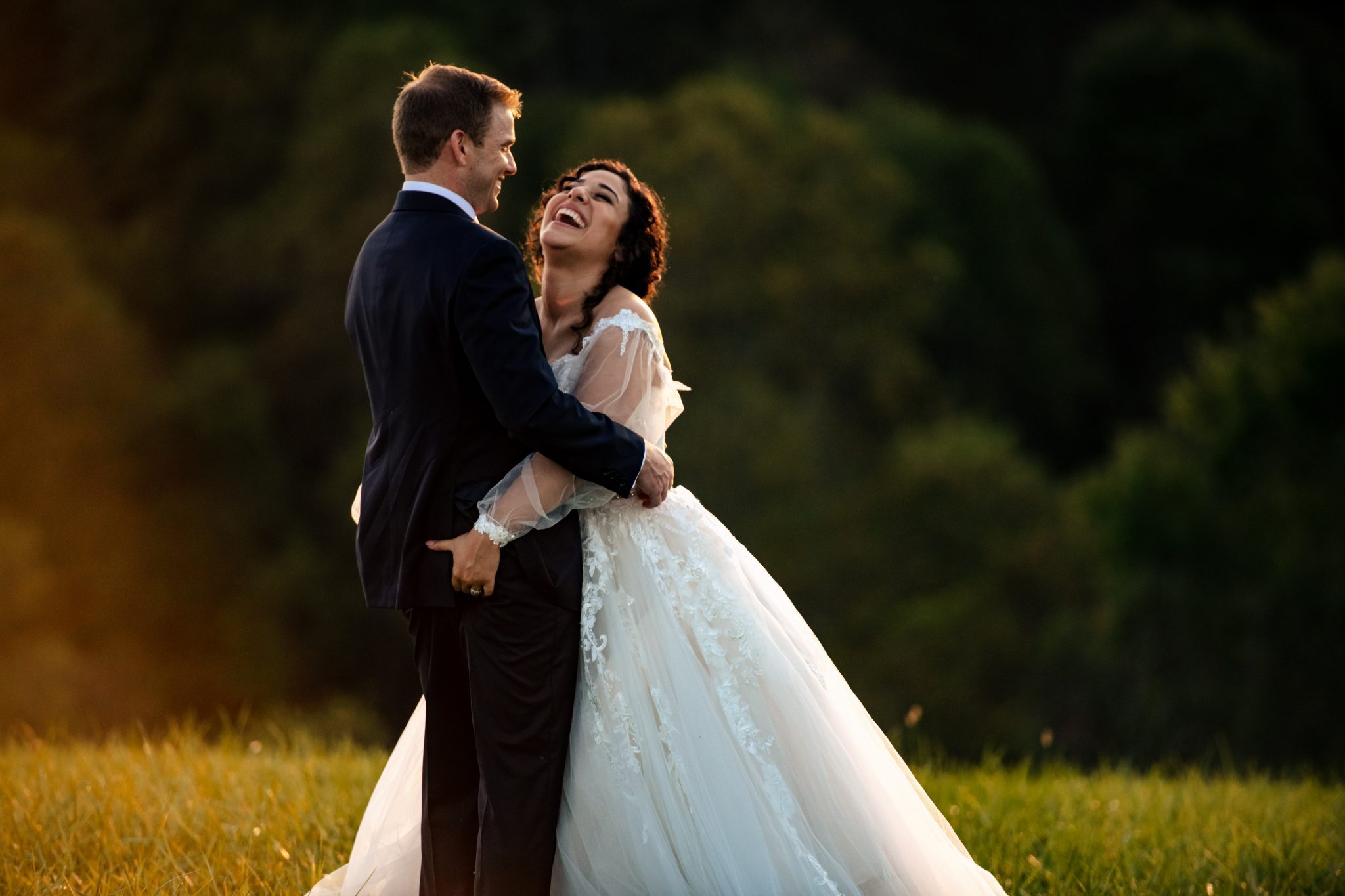 Bride grabbing Groom's butt in laughing shot while being a second photographer