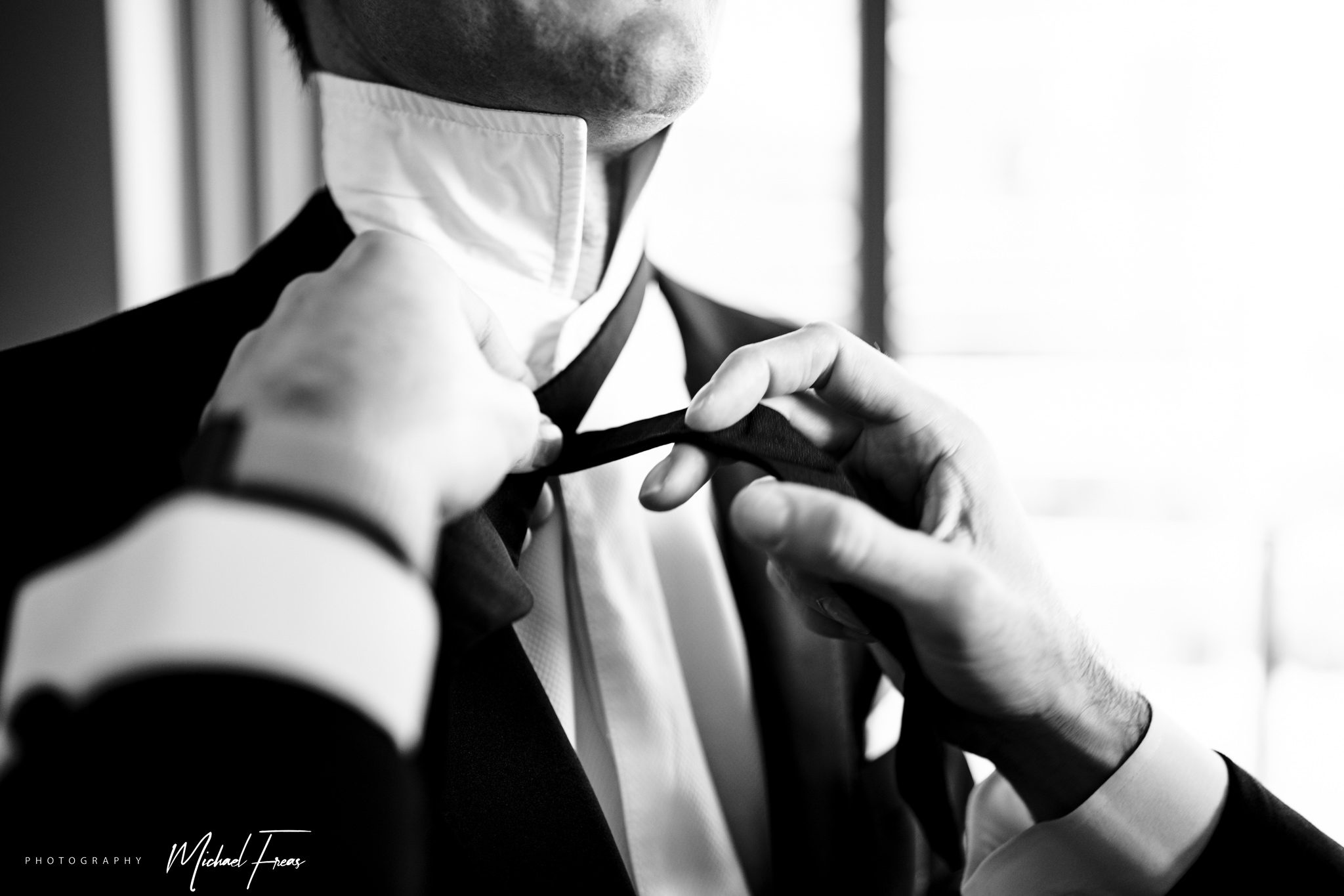 groom tying bow tie