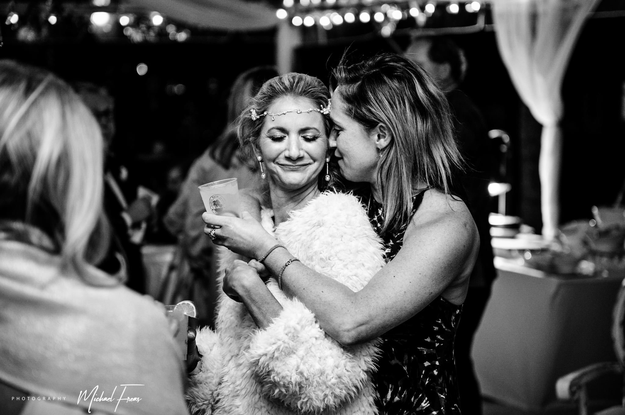 Two women hugging at a Florida Keys wedding reception.