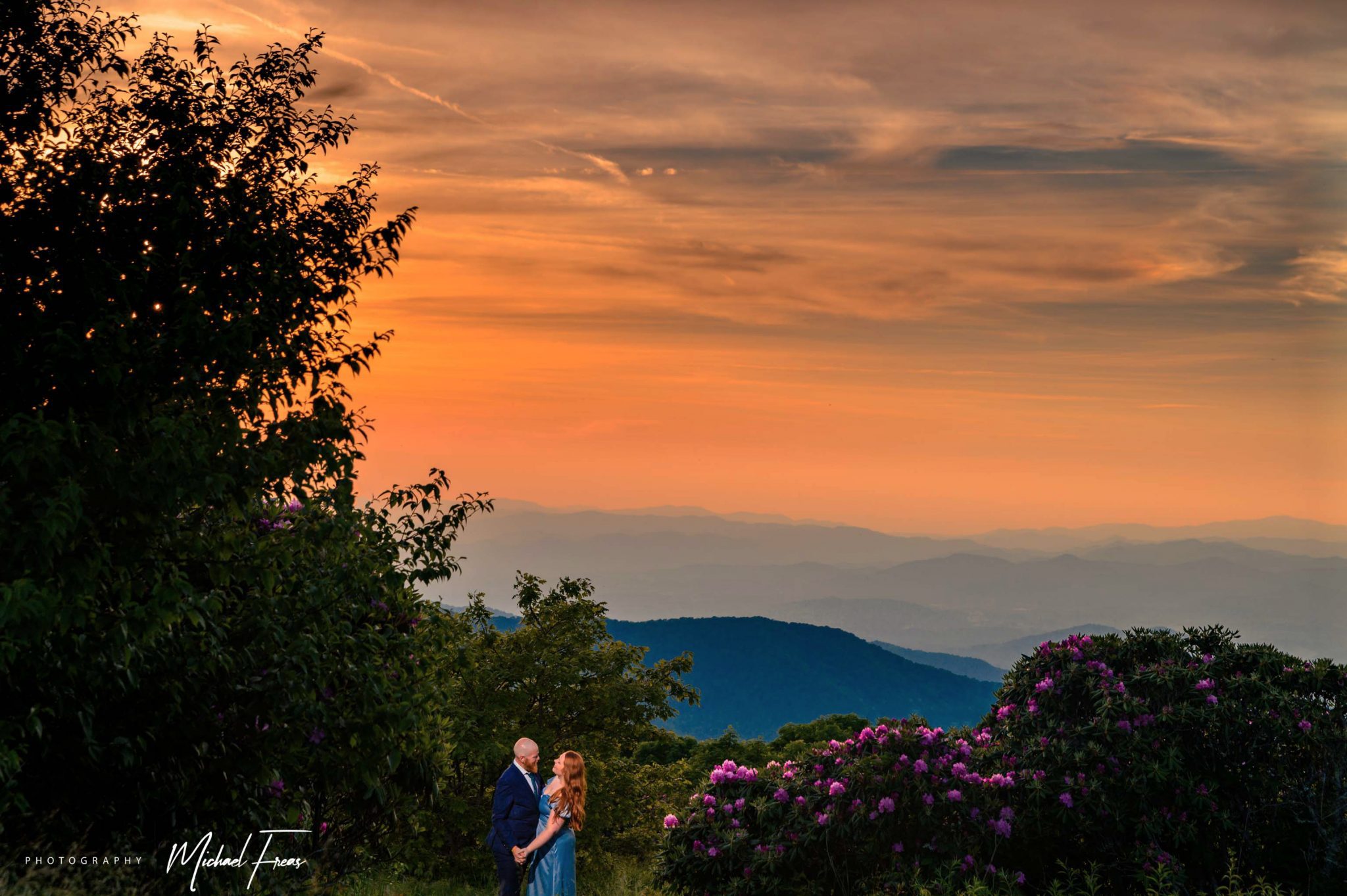 engaged couple taking mountain top sunset photos at craggy gardens
