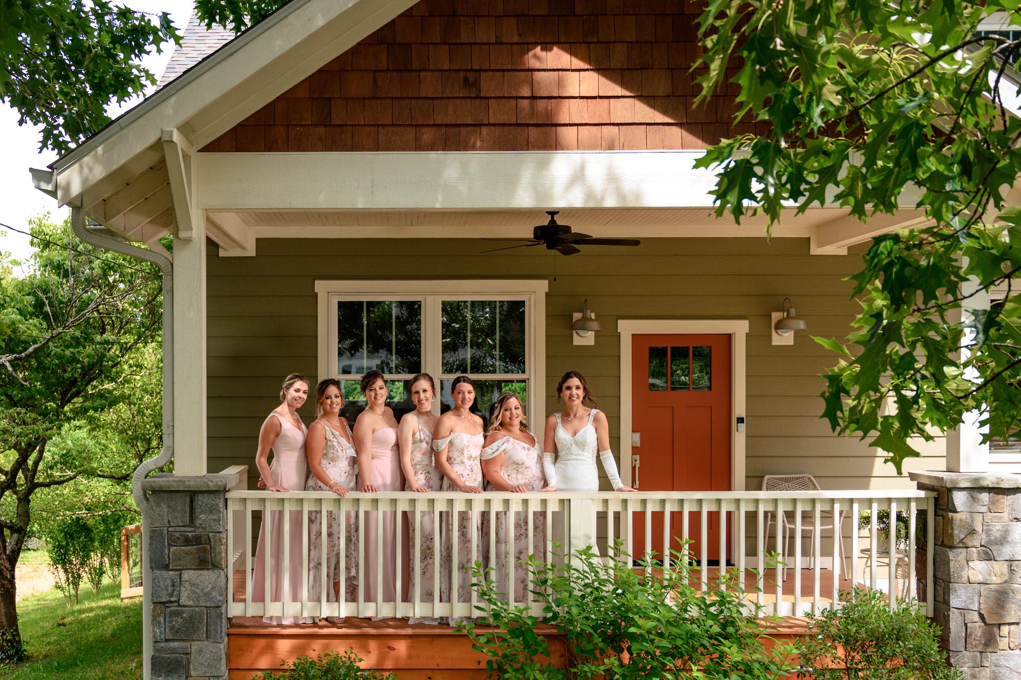A group of bridesmaids posing on the porch for a documentary wedding photographer at Crest Pavilion.