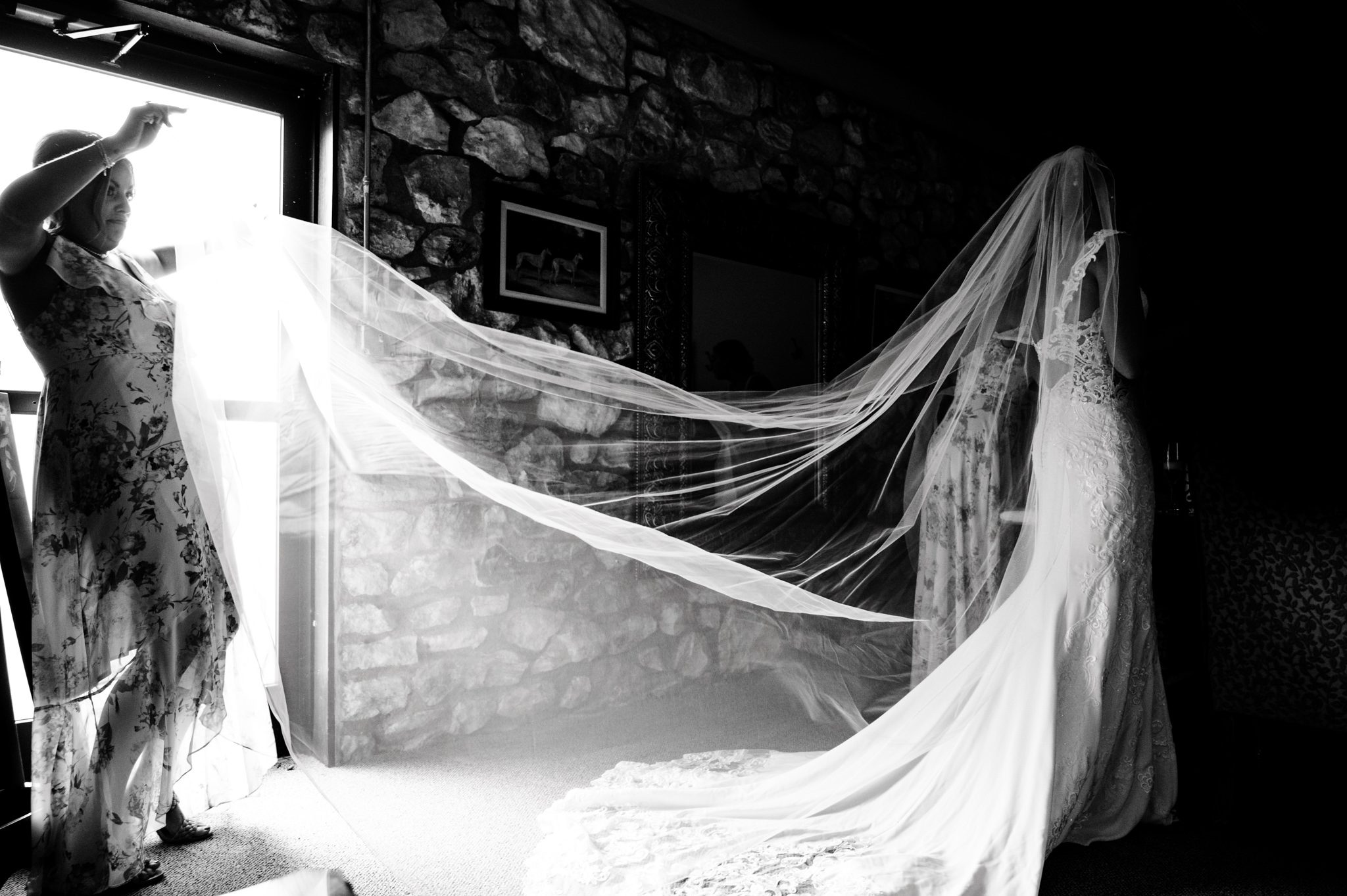 In a crest pavilion, a bride is getting ready for her wedding day, adorned with a veil, captured by a documentary wedding photographer.