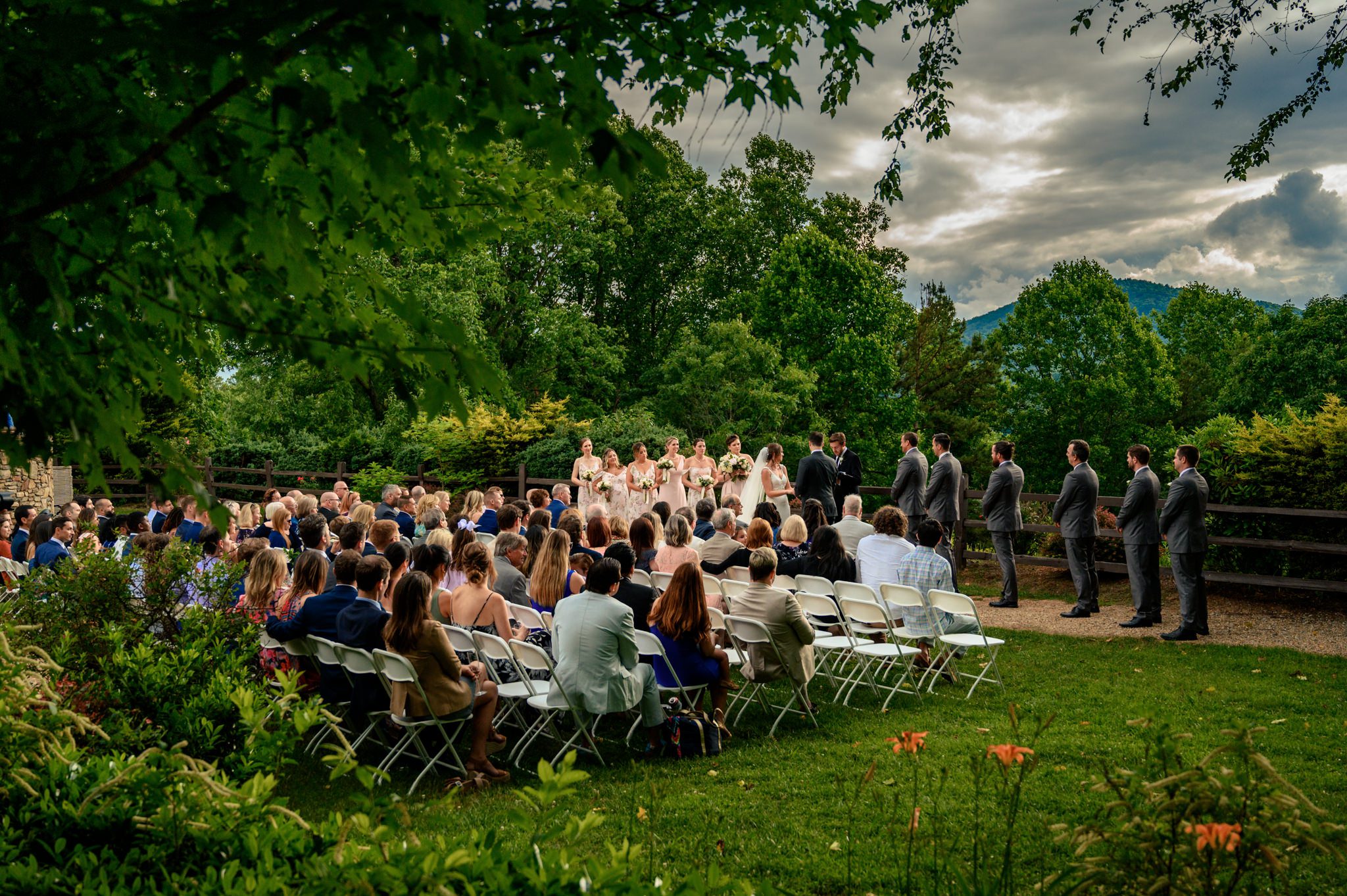 A documentary wedding photographer captures a scenic garden ceremony with mountains in the background at Crest Pavilion.