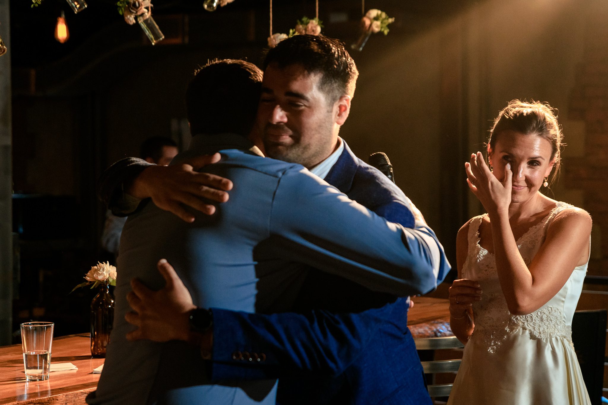 A bride and groom hugging at their wedding reception captured by a documentary wedding photographer at Crest Pavilion.