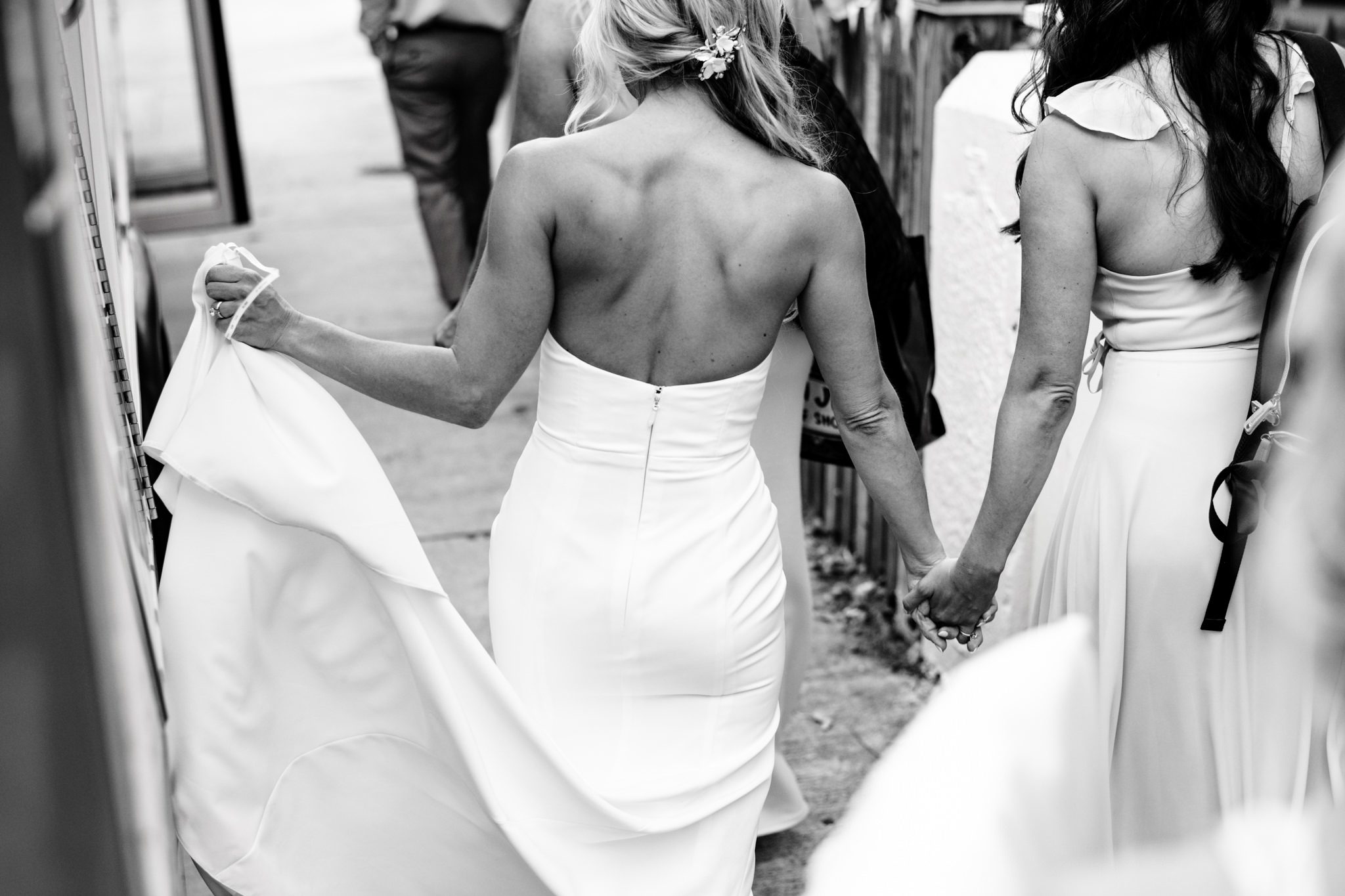 bride and bridesmaid holding hands and walking to trolley in key west