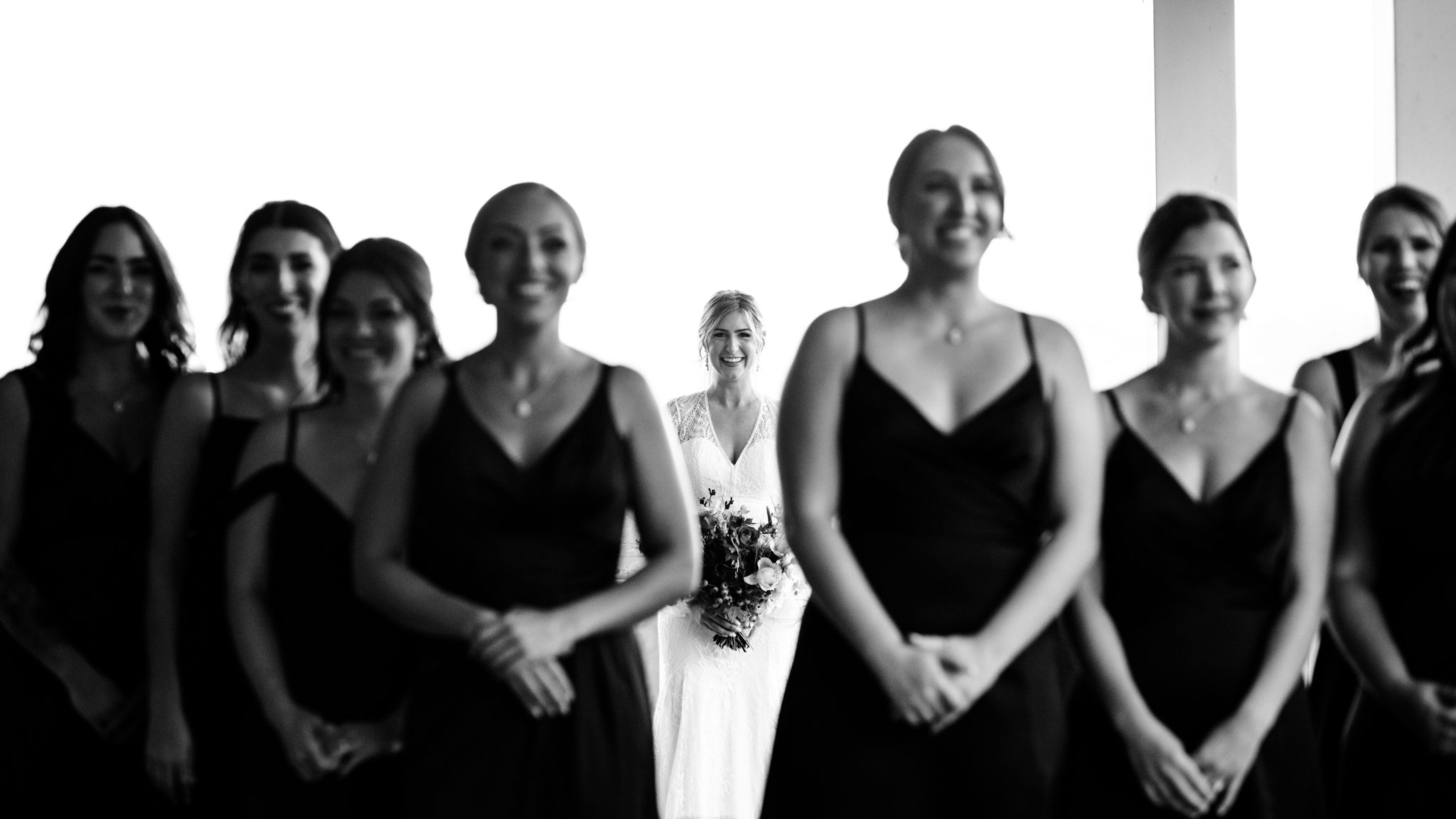 Bridesmaids standing smiling with bride in background during first look at the ridge wedding venue in Asheville North Carolina