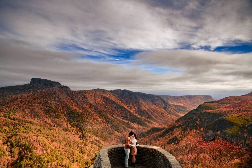 Engaged couple kissing at Wiseman's view in Linville Gorge