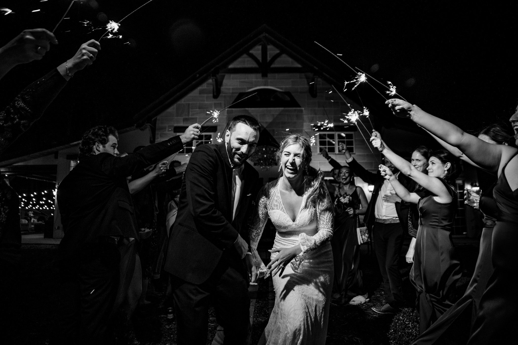 An exquisite Asheville wedding photographer captures a blissful bride and groom with sparklers on their special day.