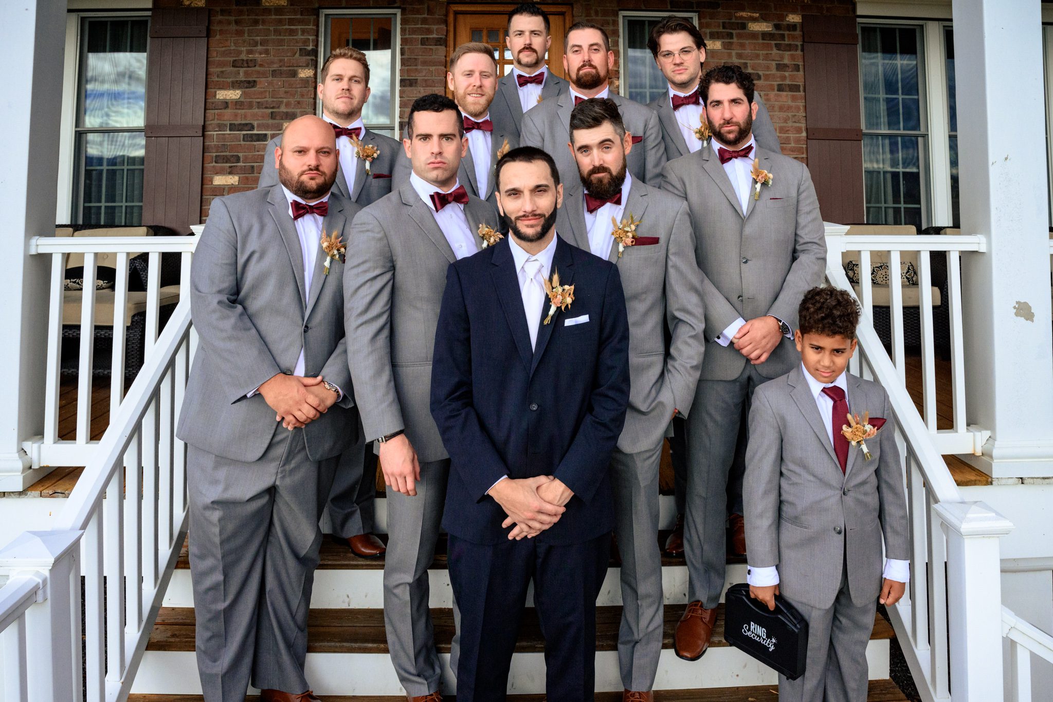 groom and groomsmen huddle together for a photo on the steps of the residence at the ridge asheville