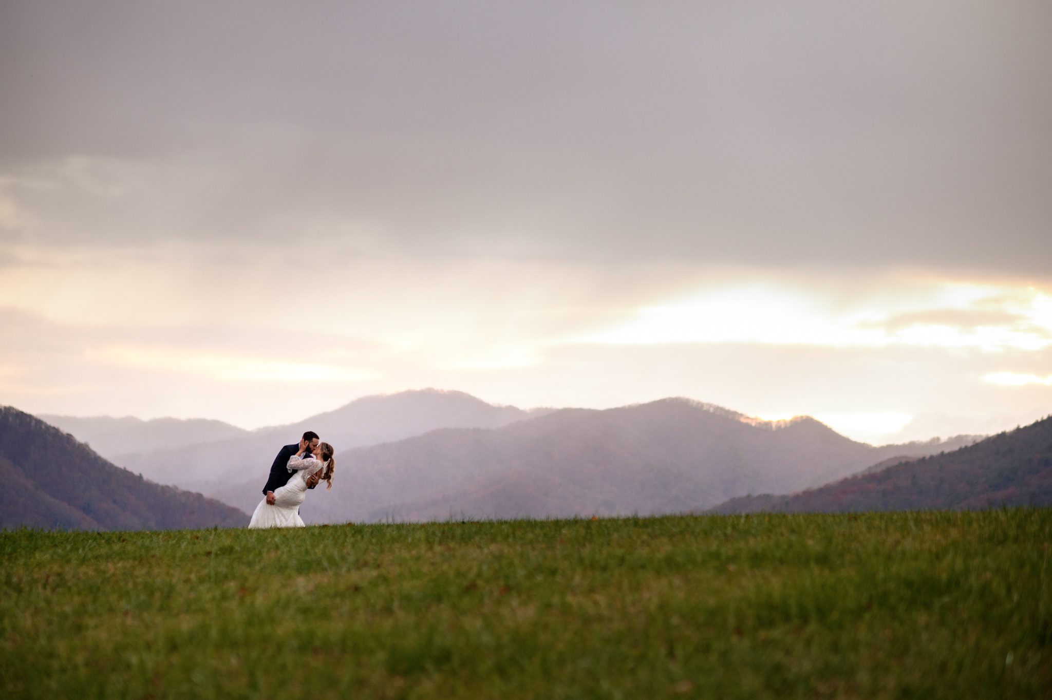 bride and groom pose for wedding photos at sunset at the ridge asheville wedding venue