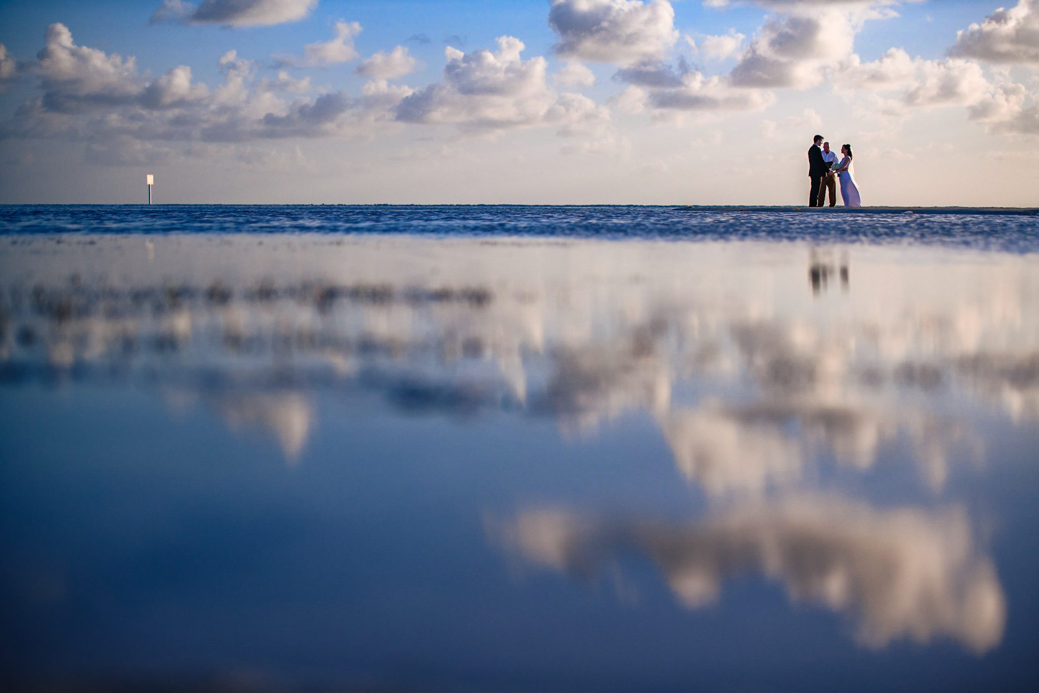 couple has elopement ceremony on sandbar in florida keys at little palm island with calm water in foreground