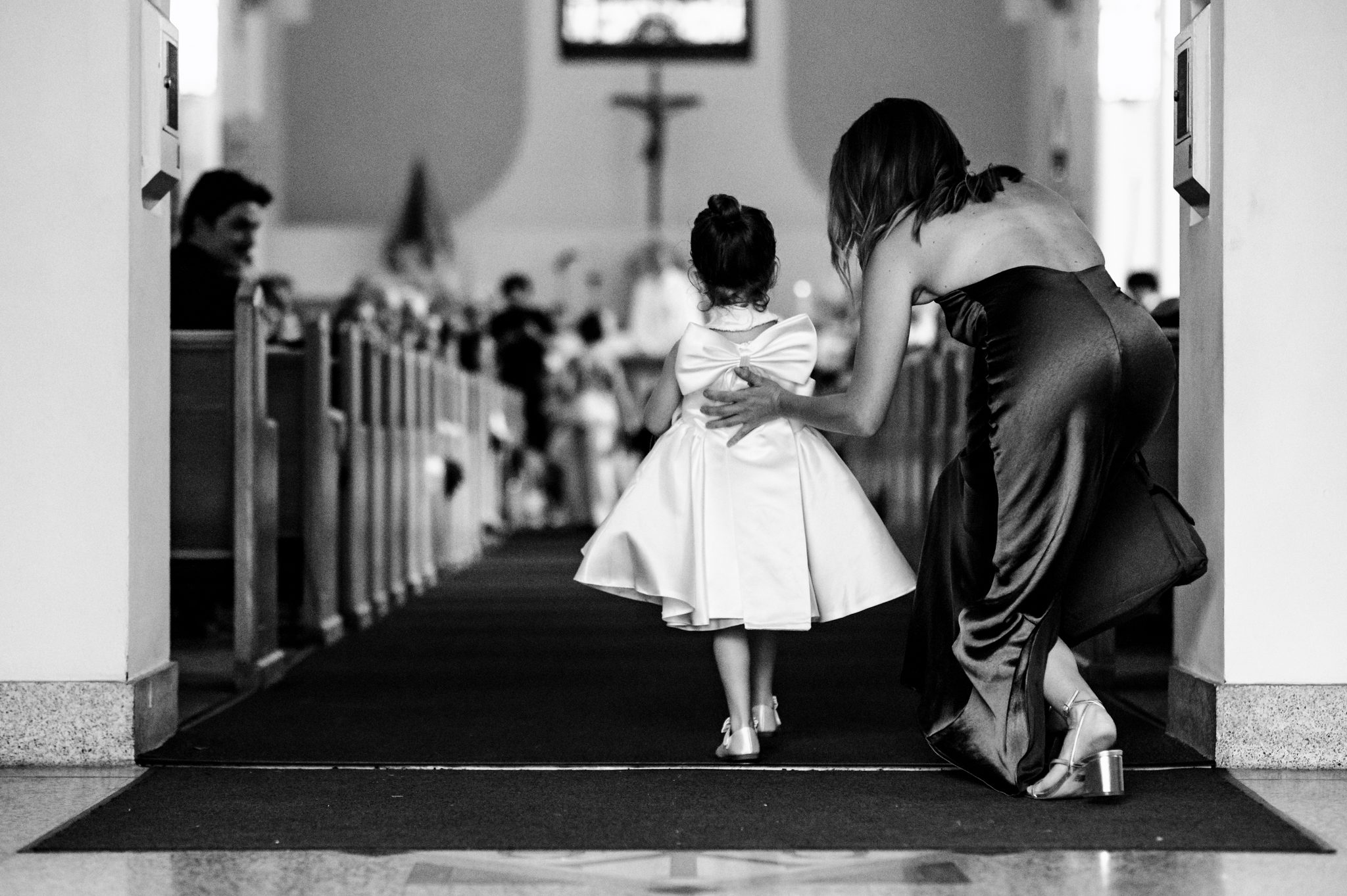 mother giving her daughter a helpful push down the aisle