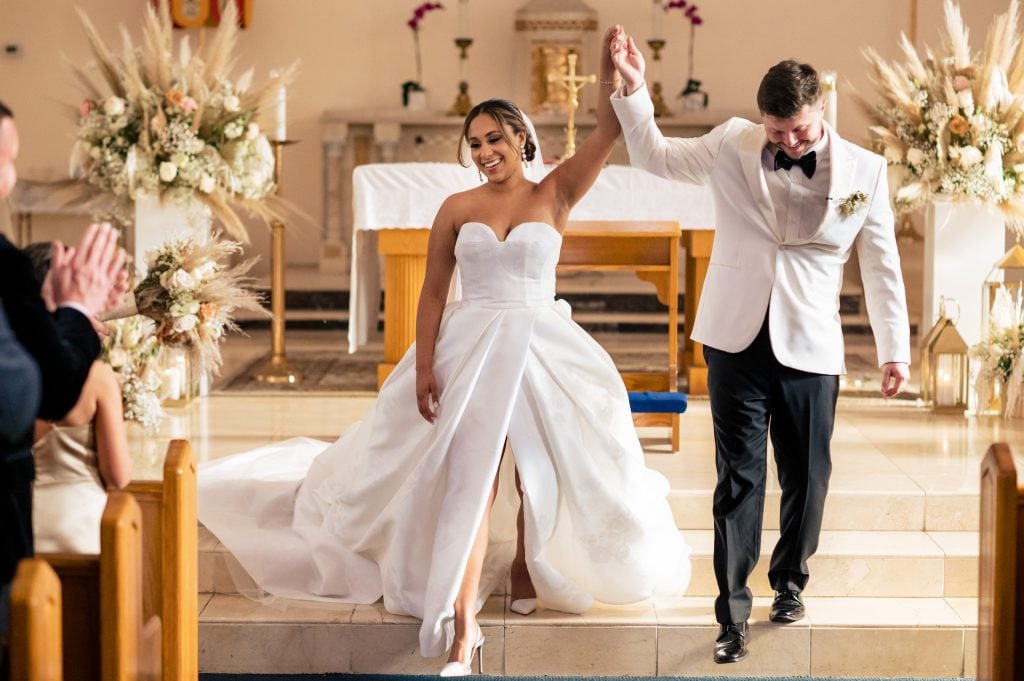 bride and groom celebrate after being married in the basilica of st marys in key west florida