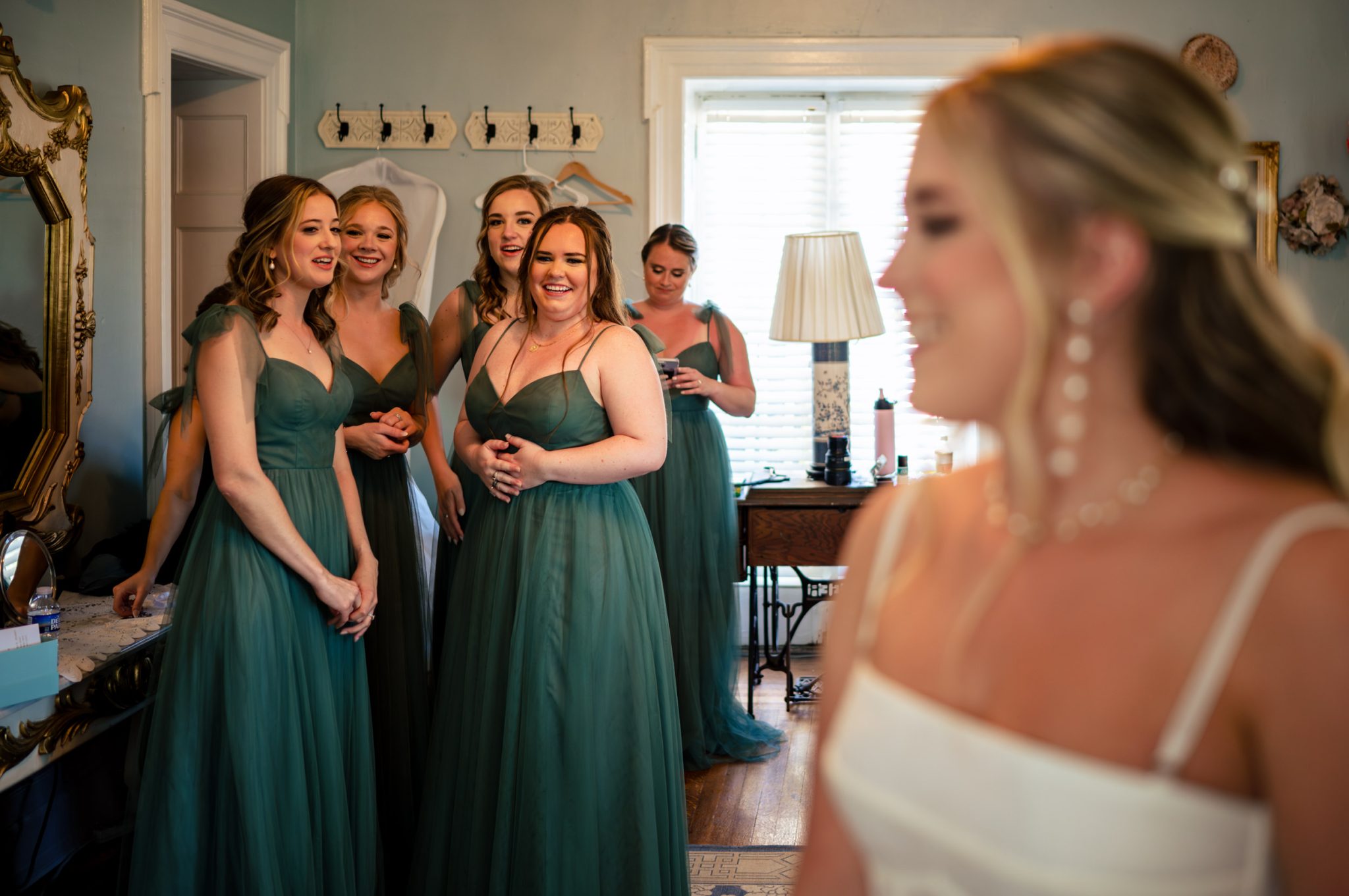 A bride and her bridesmaids are getting ready in a room.