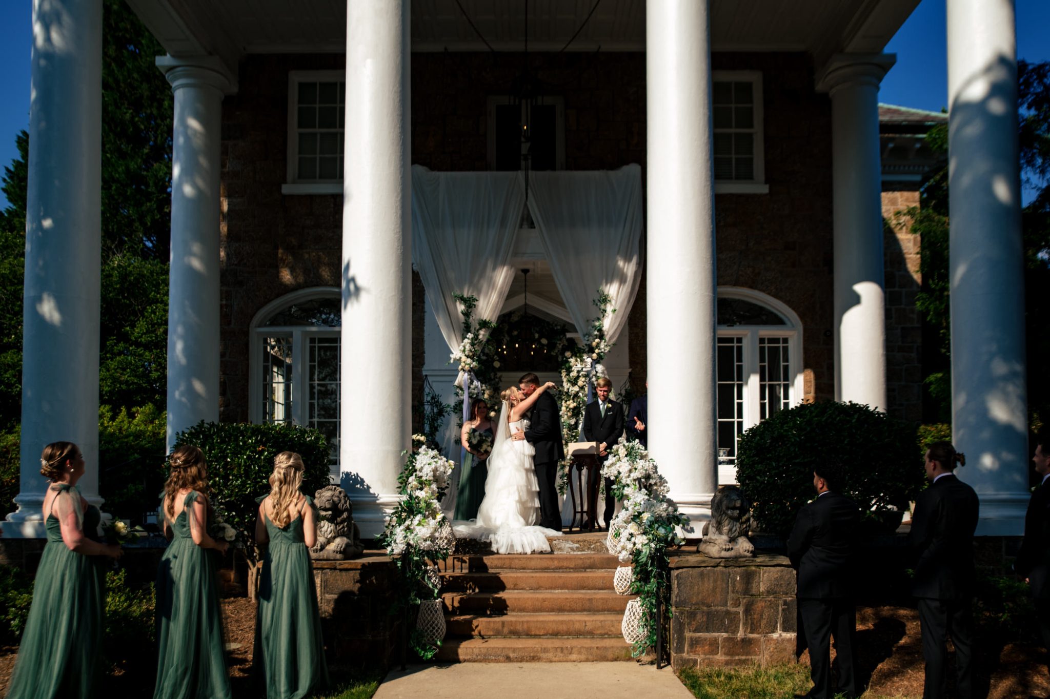A wedding ceremony in front of a mansion.