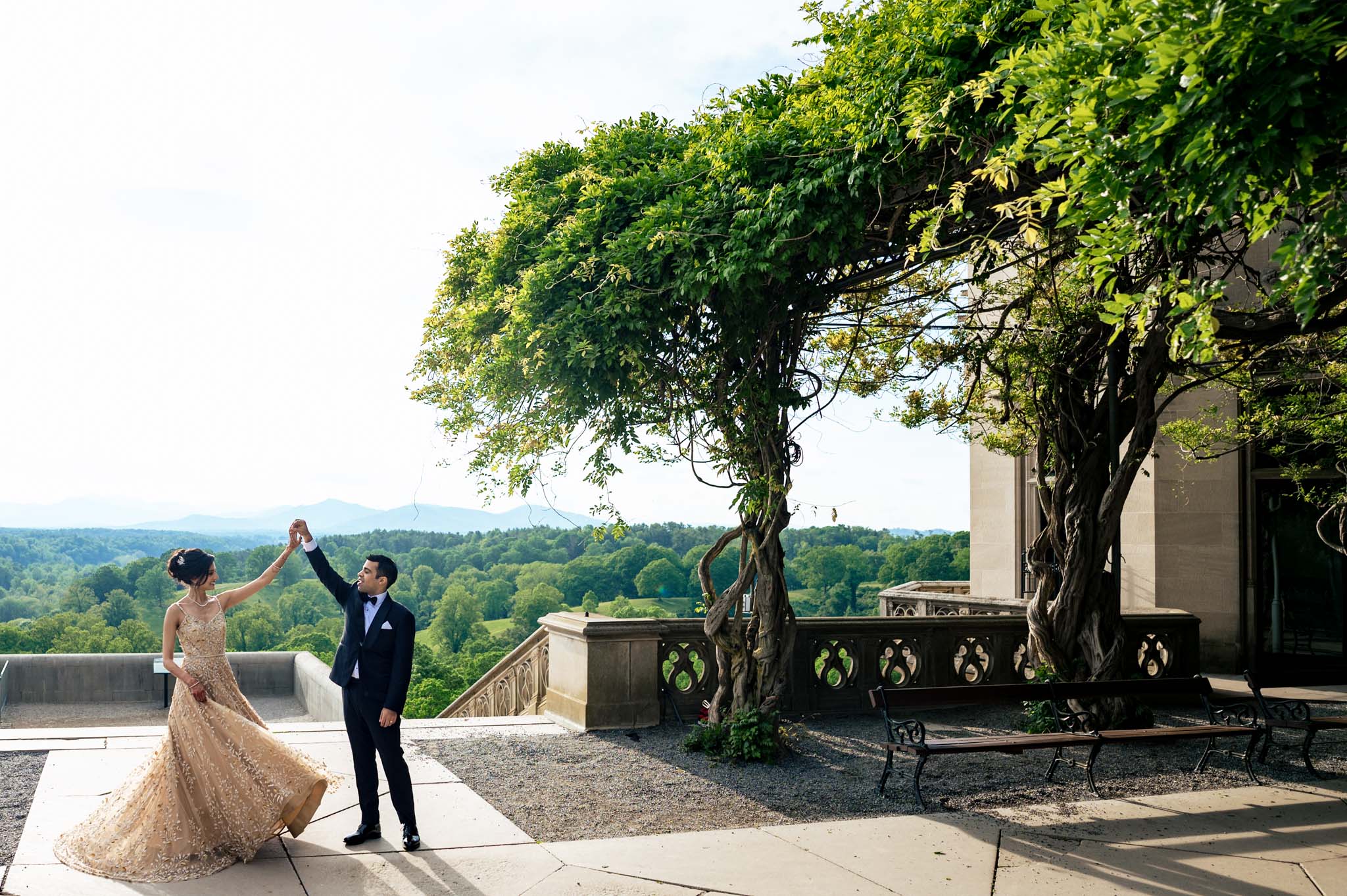 A bride and groom having a Biltmore Estate wedding in front of a building with a view.