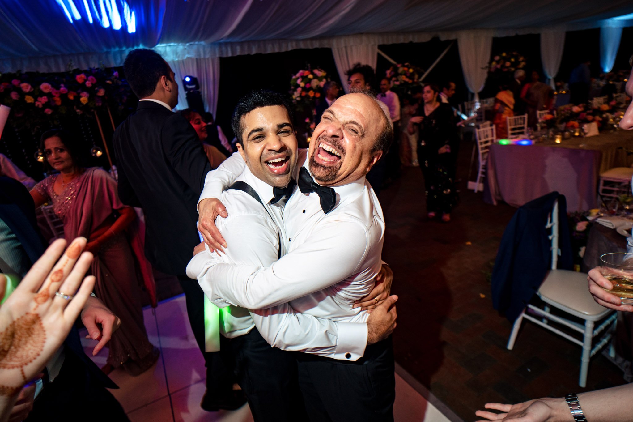 Two men hugging at a Biltmore Estate wedding reception.