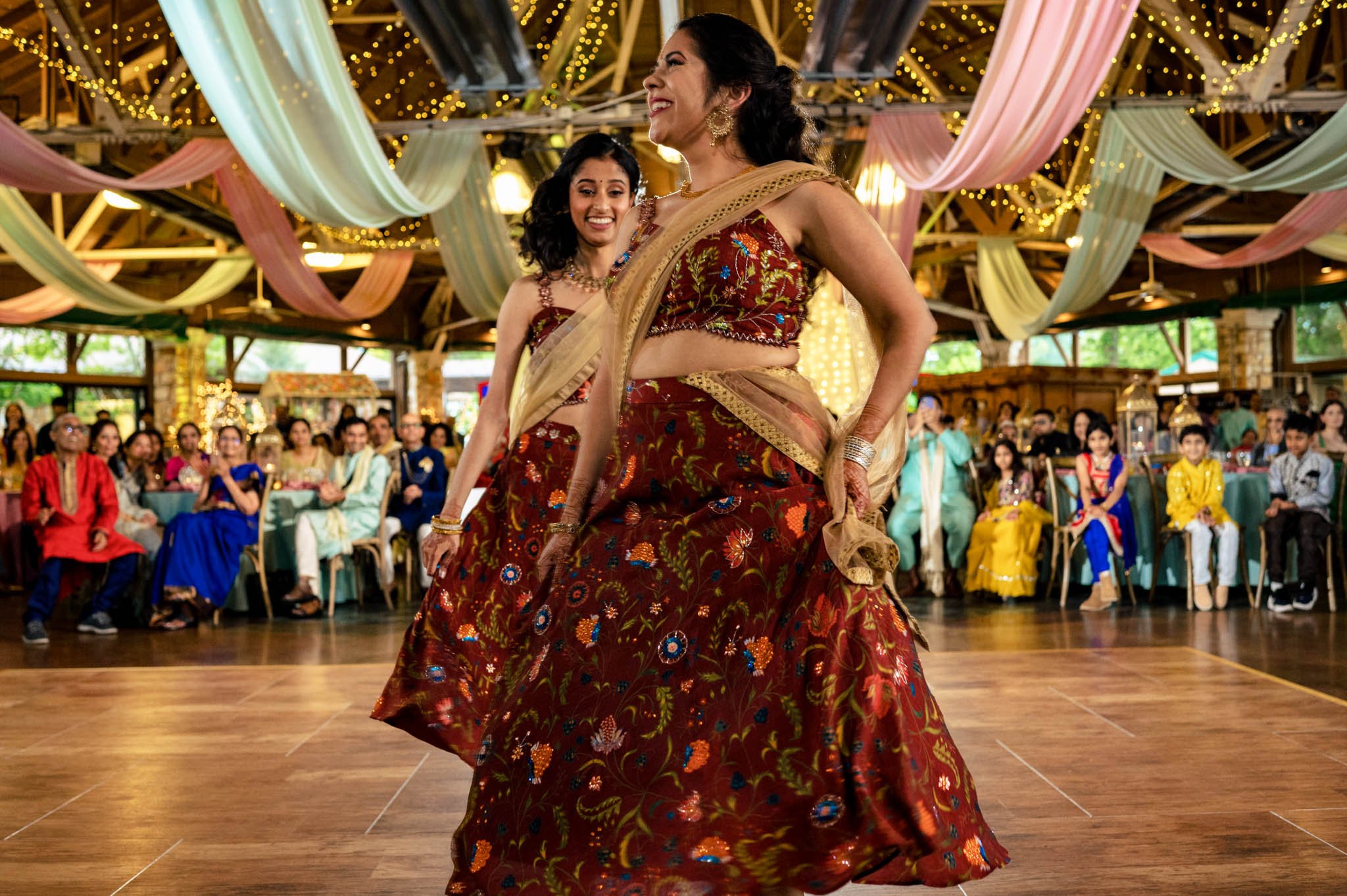 Two Indian women dancing on a stage at a Biltmore Estate wedding.