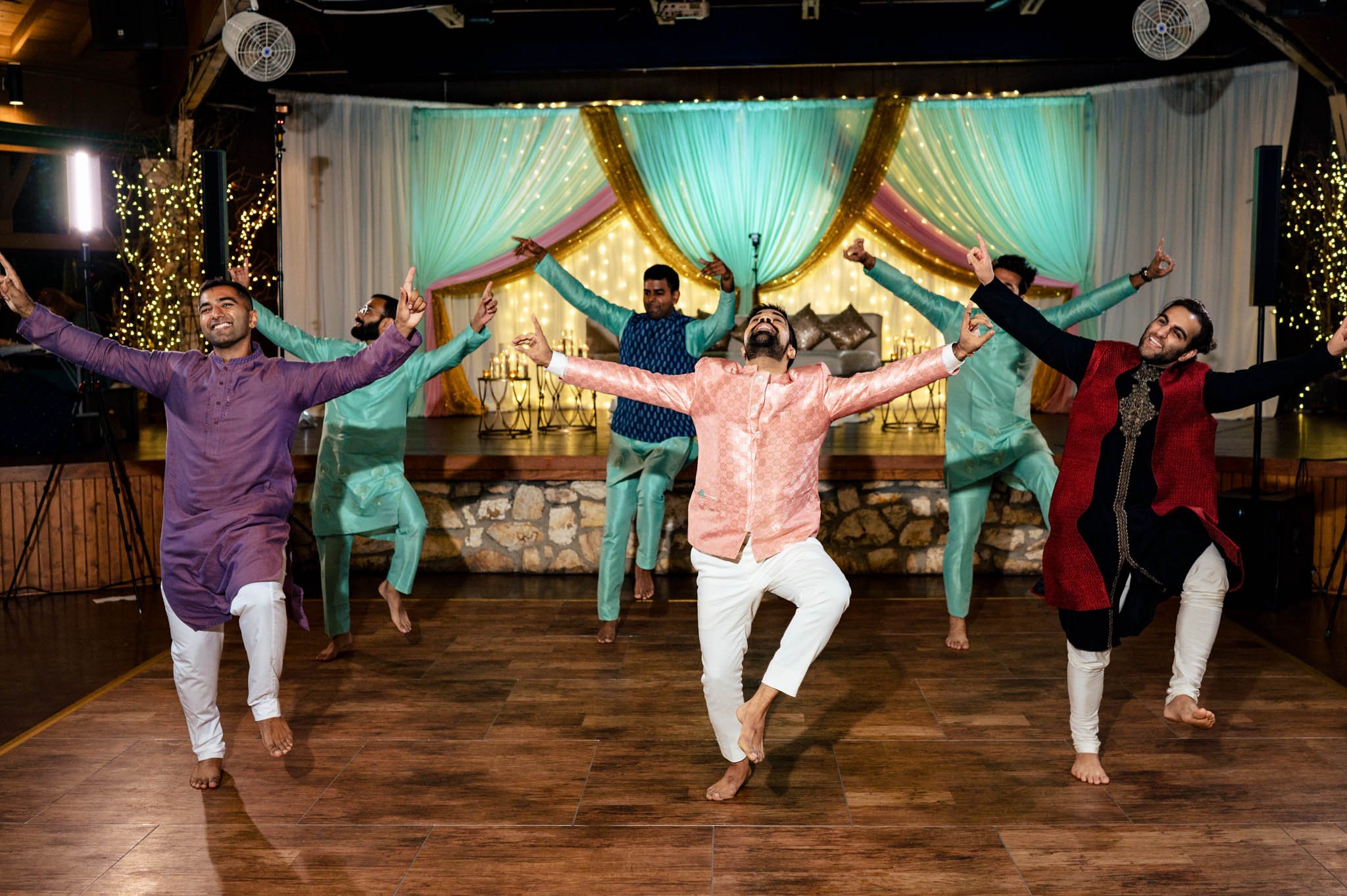 A group of Indian men dancing on a stage at a Biltmore Estate wedding.