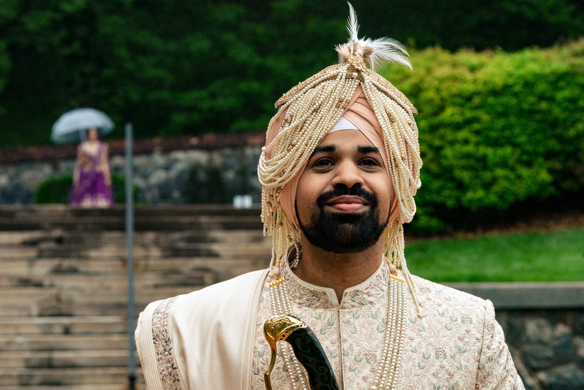 A man in an indian turban poses for a wedding photo at the Biltmore Estate.