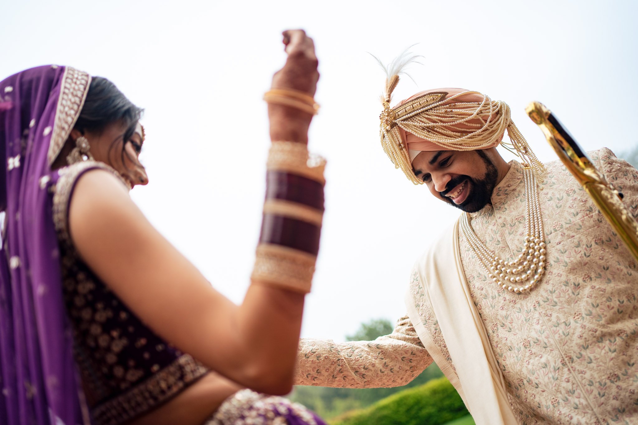 An indian bride and groom dancing with each other.