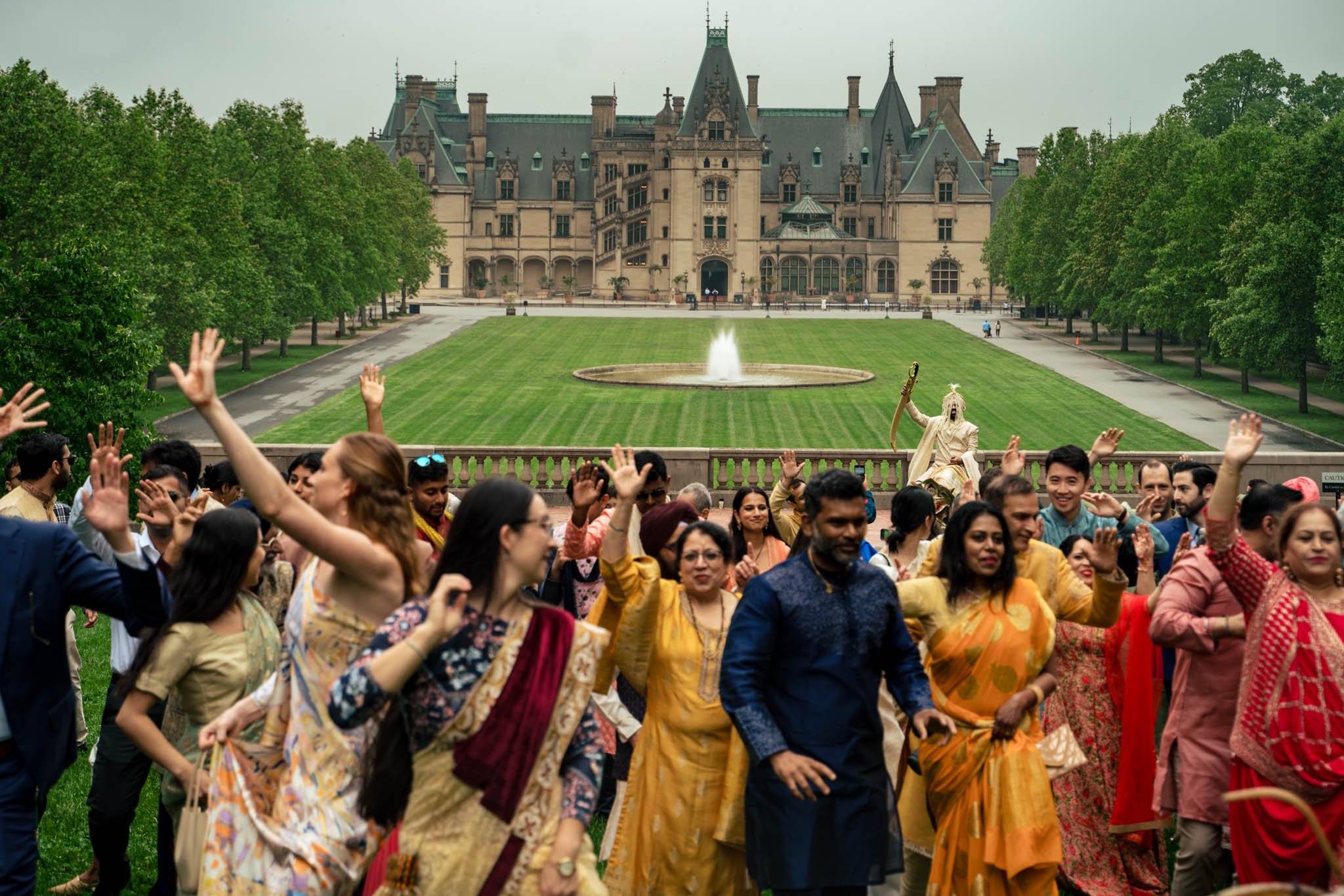A group of people dancing in front of the Biltmore Estate.