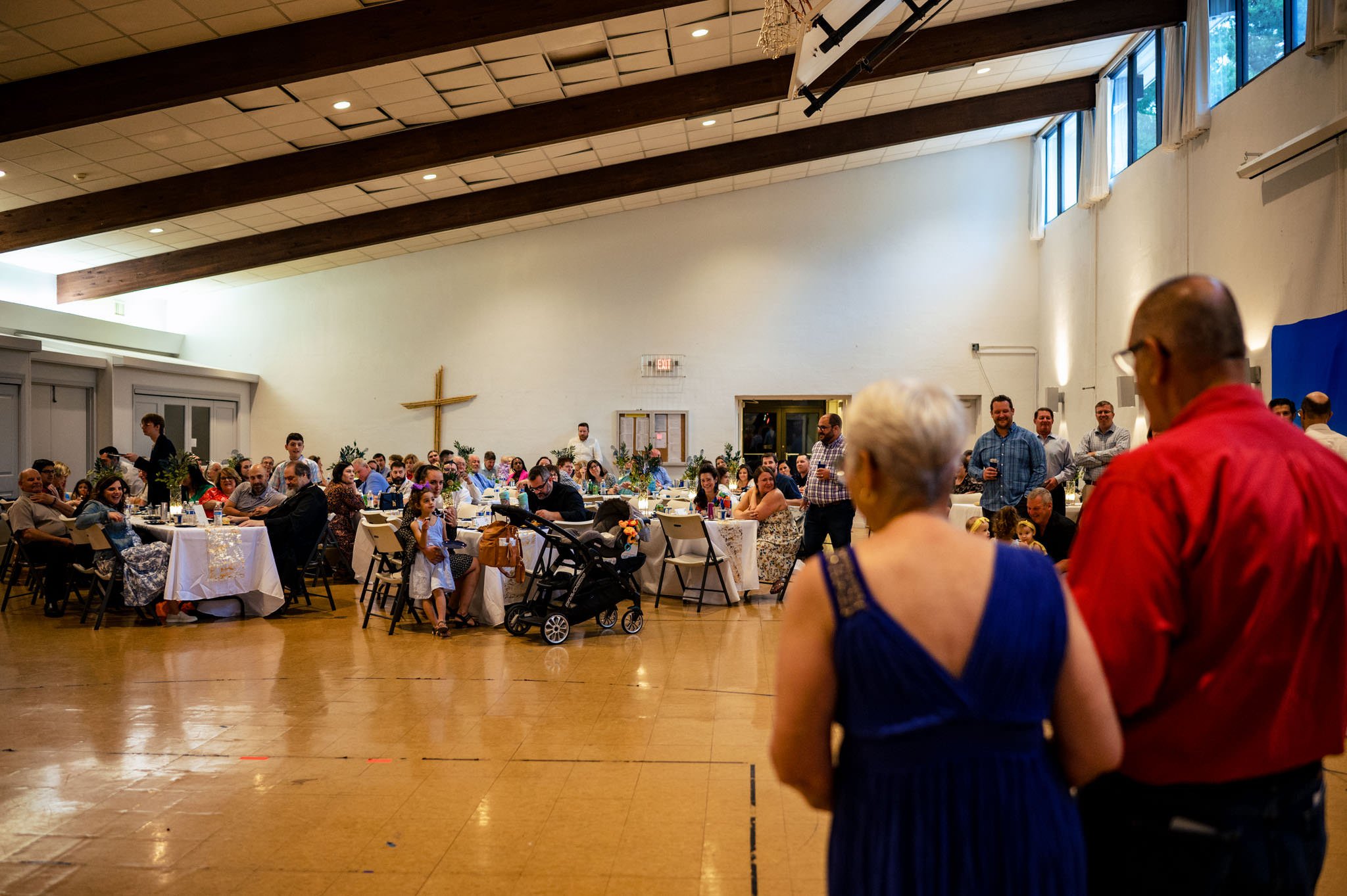 A group of people in a large room captured by a Raleigh NC wedding photographer.