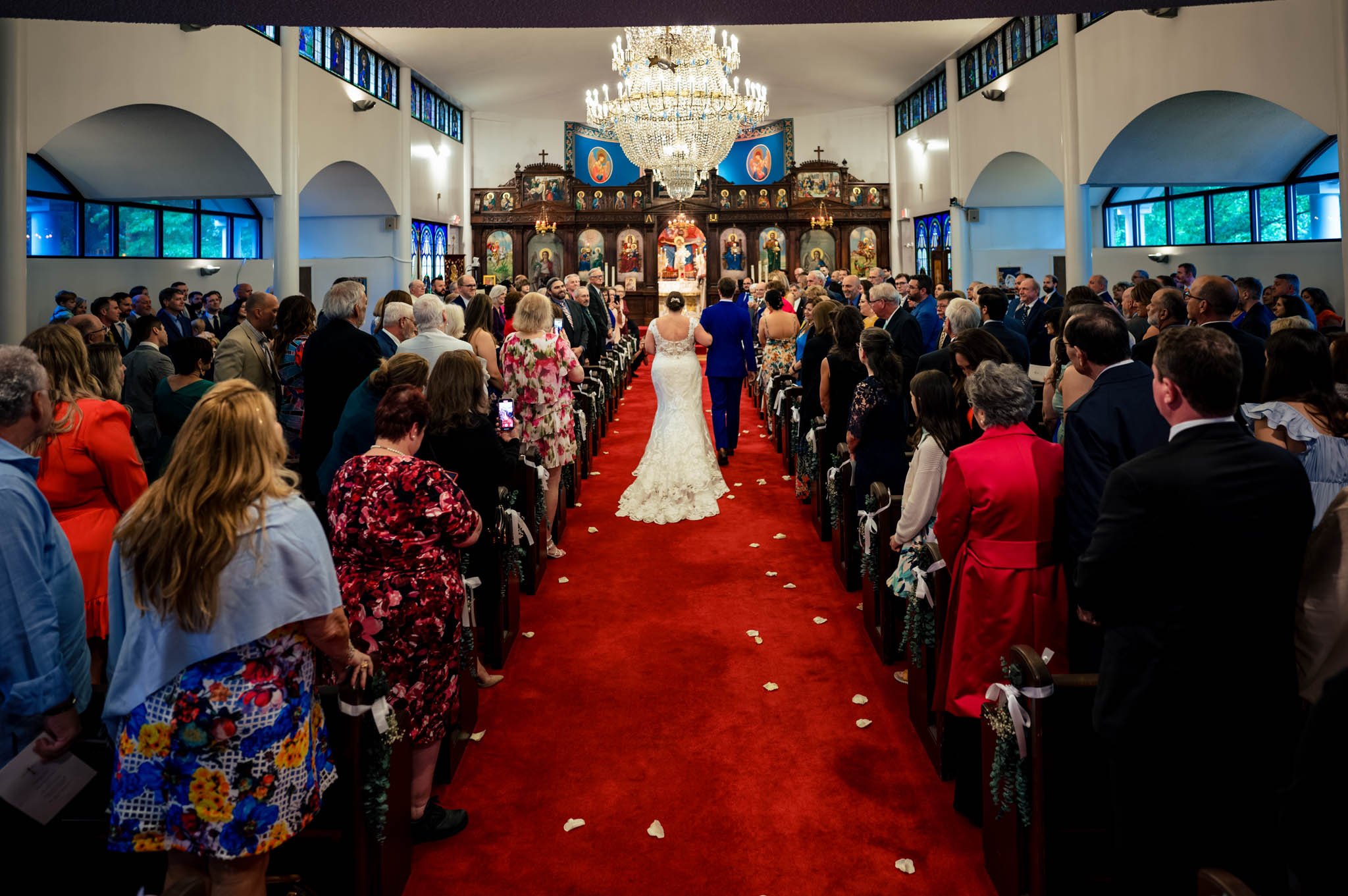 Raleigh NC wedding photographer captures a bride and groom walking down the aisle in a church.